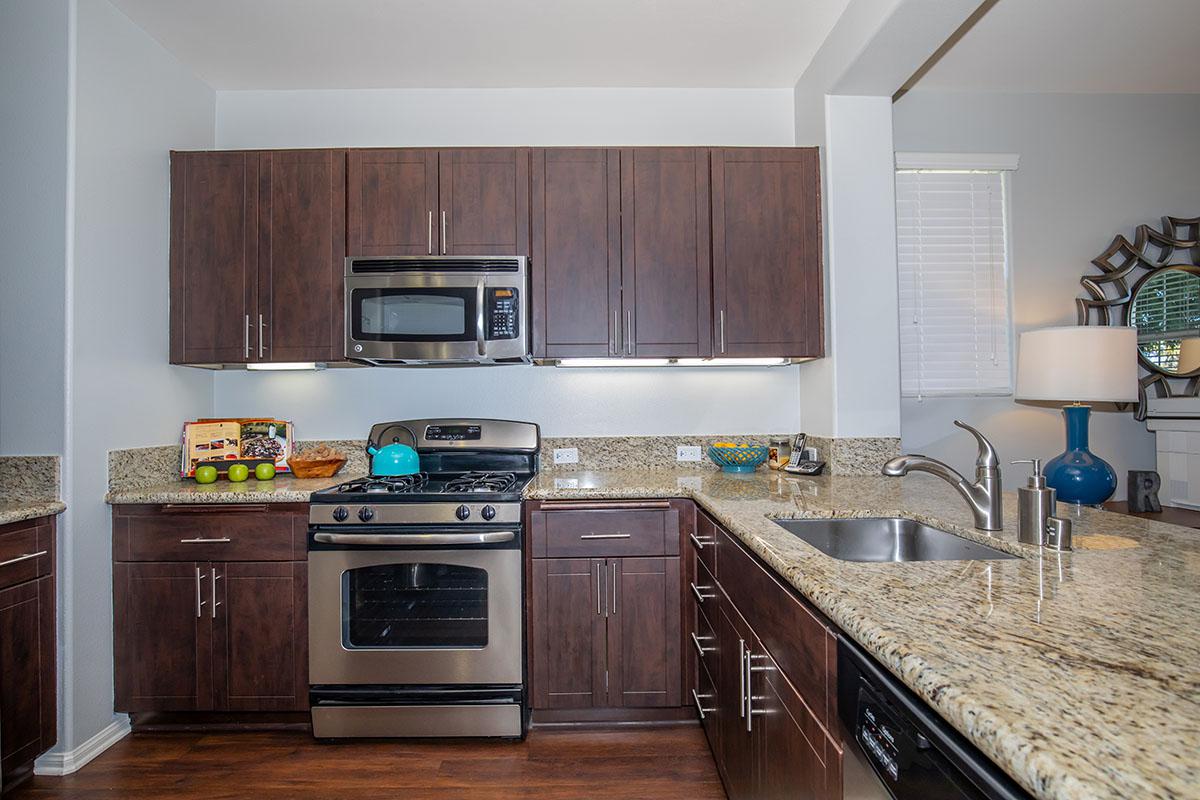a modern kitchen with stainless steel appliances and wooden cabinets