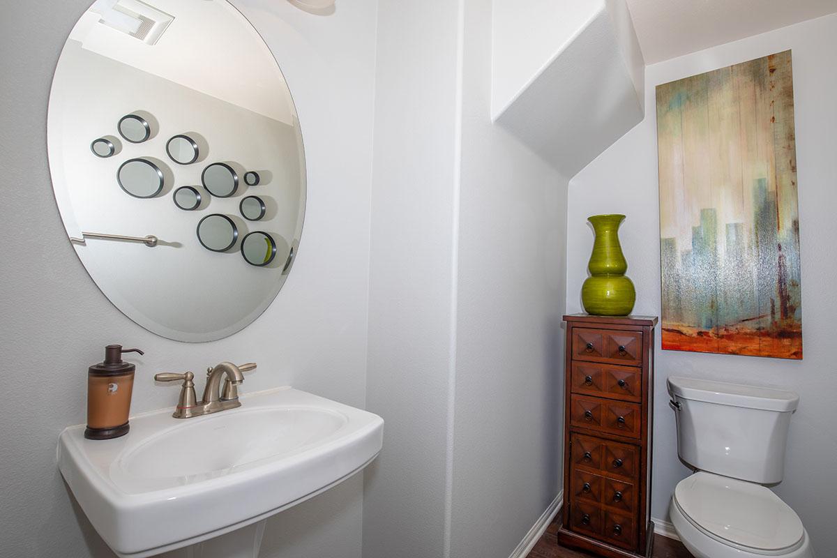 a white sink sitting under a mirror