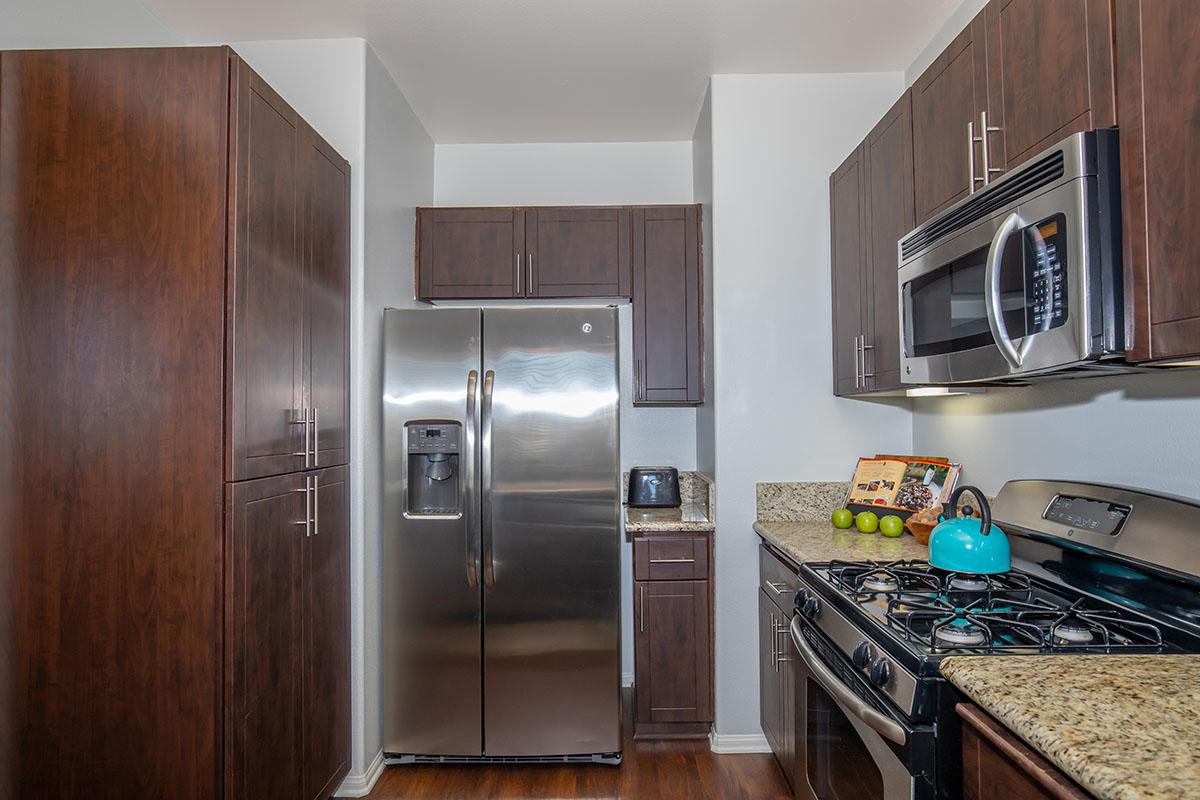 a modern kitchen with stainless steel appliances and wooden cabinets