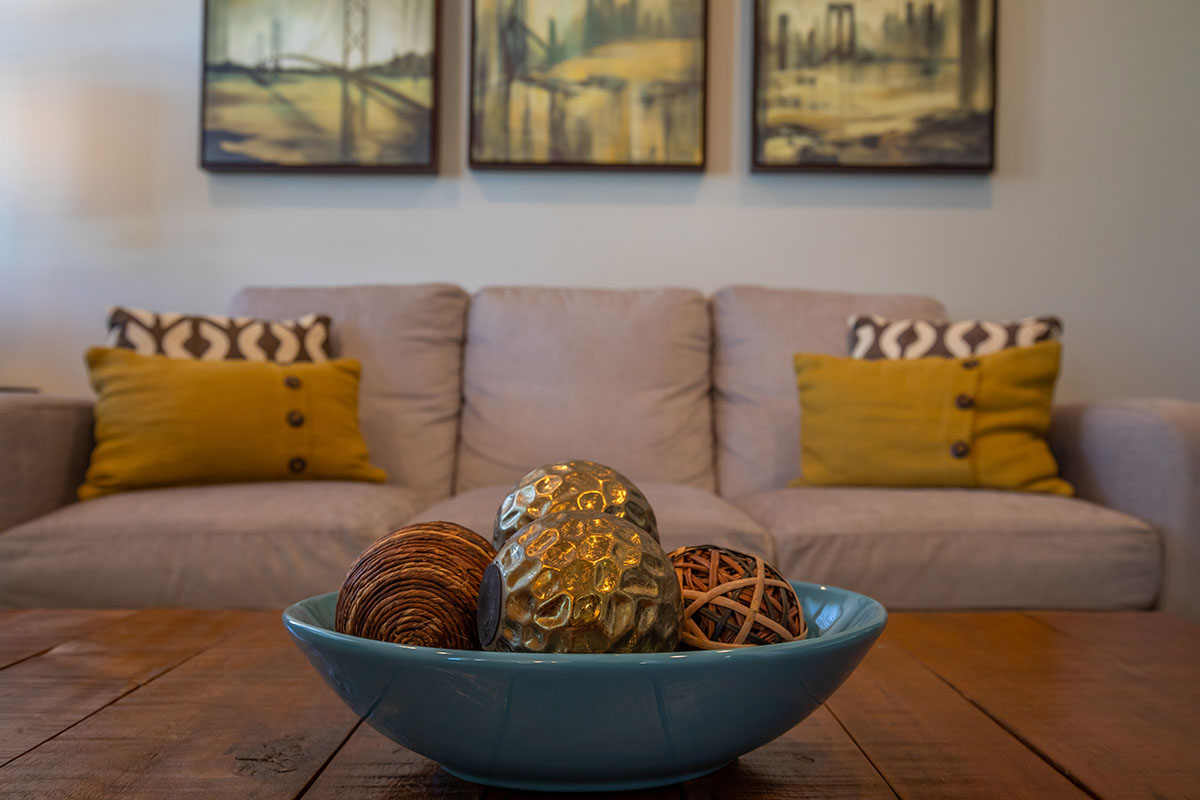 a glass with a blue seat sitting in a living room