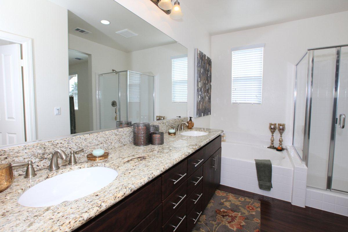 a bedroom with a large mirror next to a sink