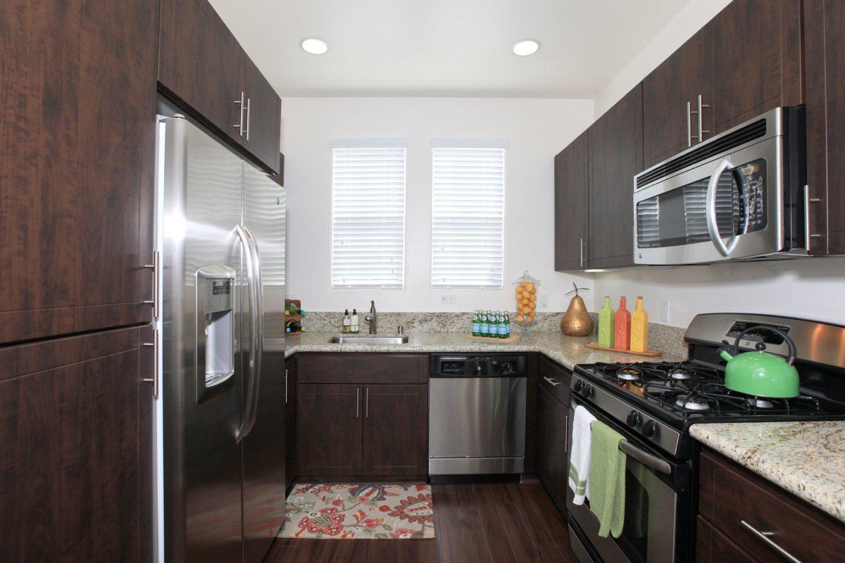 a modern kitchen with stainless steel appliances and wooden cabinets