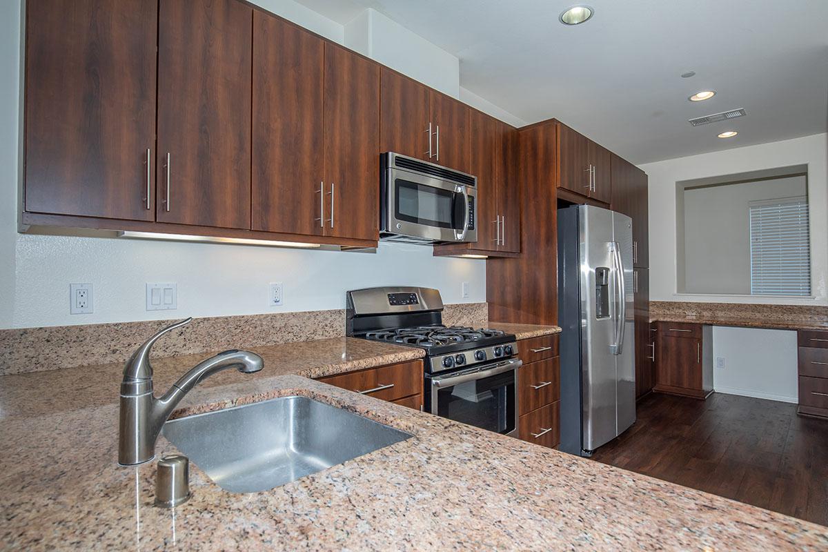 a modern kitchen with stainless steel appliances and wooden cabinets