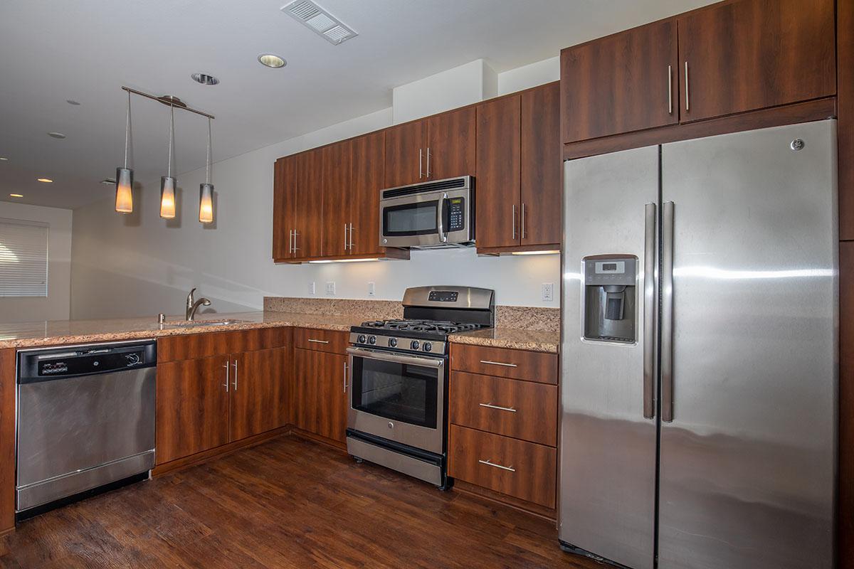 a large kitchen with stainless steel appliances and wooden cabinets