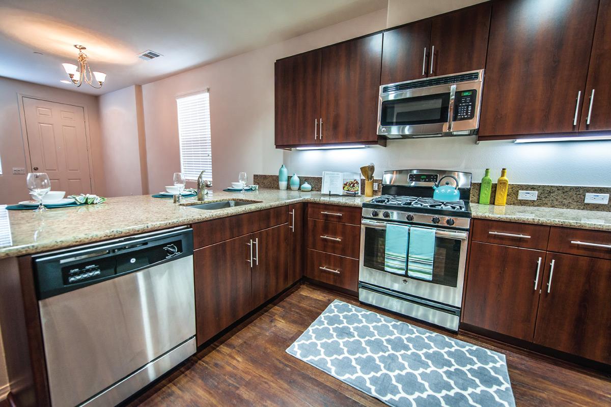 a modern kitchen with stainless steel appliances and wooden cabinets