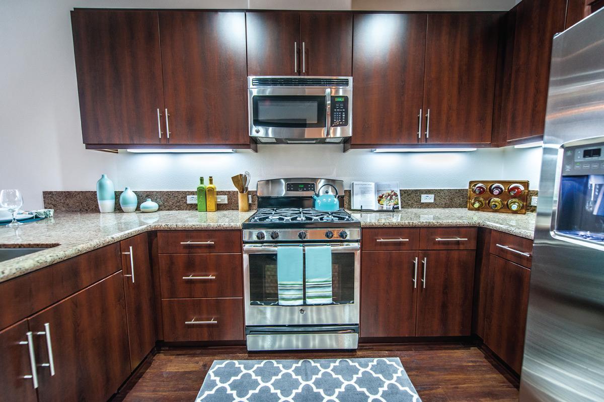 a modern kitchen with stainless steel appliances and wooden cabinets