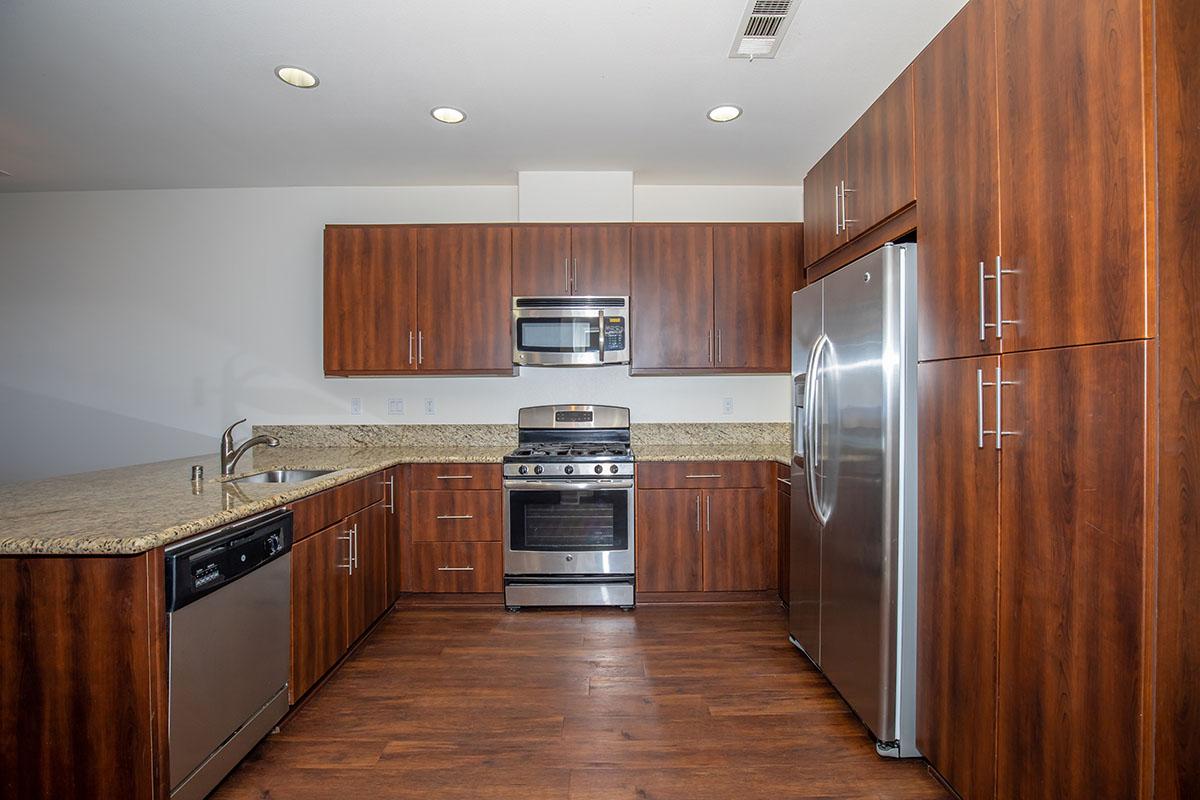 a modern kitchen with stainless steel appliances and wooden cabinets