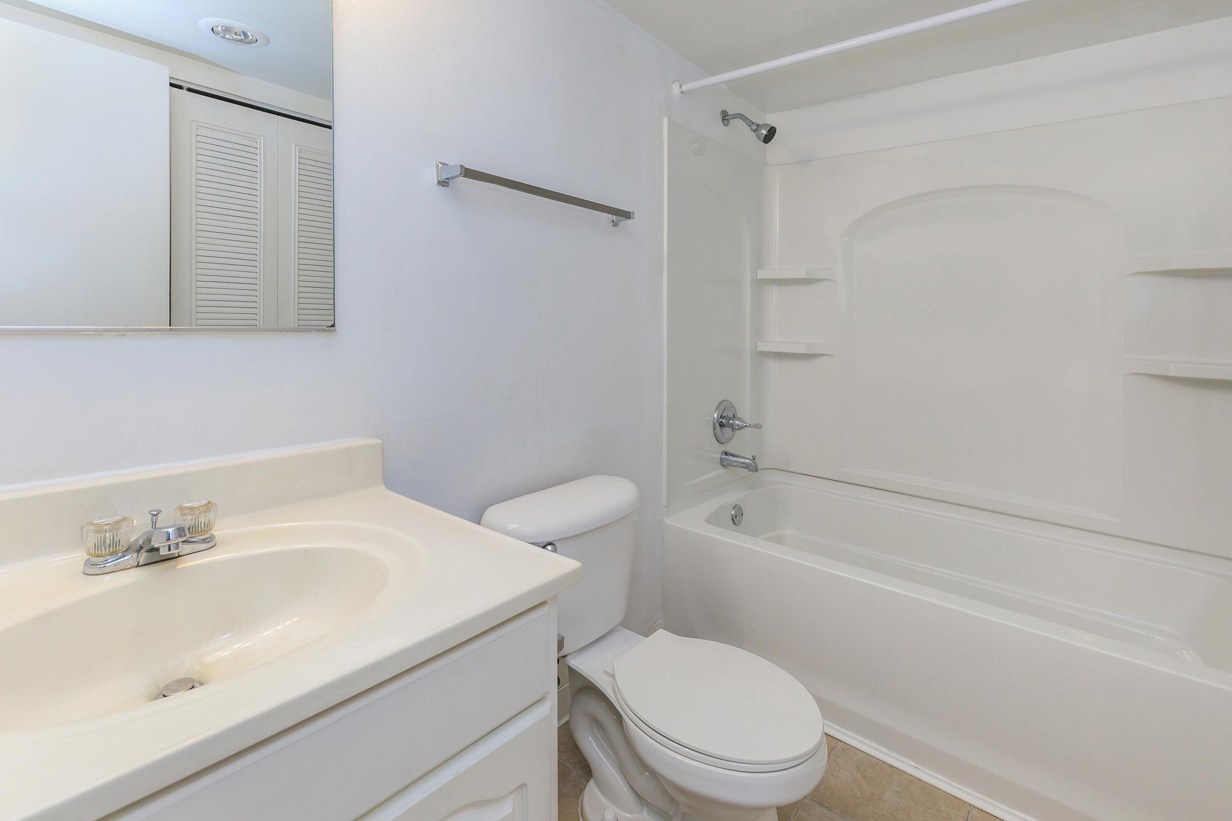 a white sink sitting under a mirror