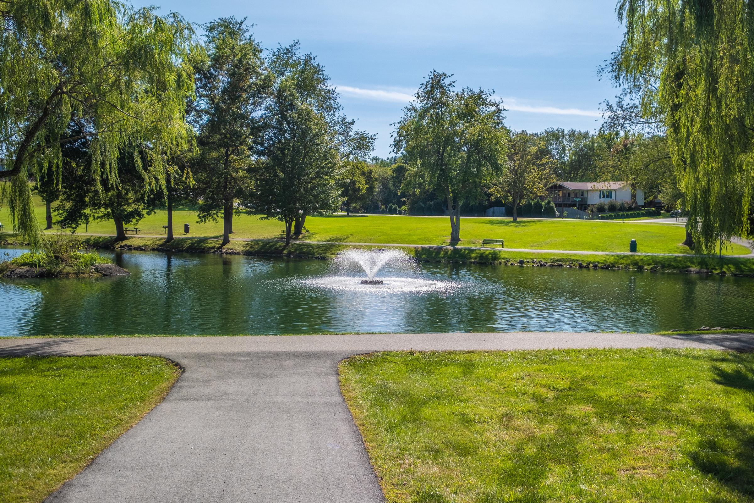 a river running through a park next to a body of water