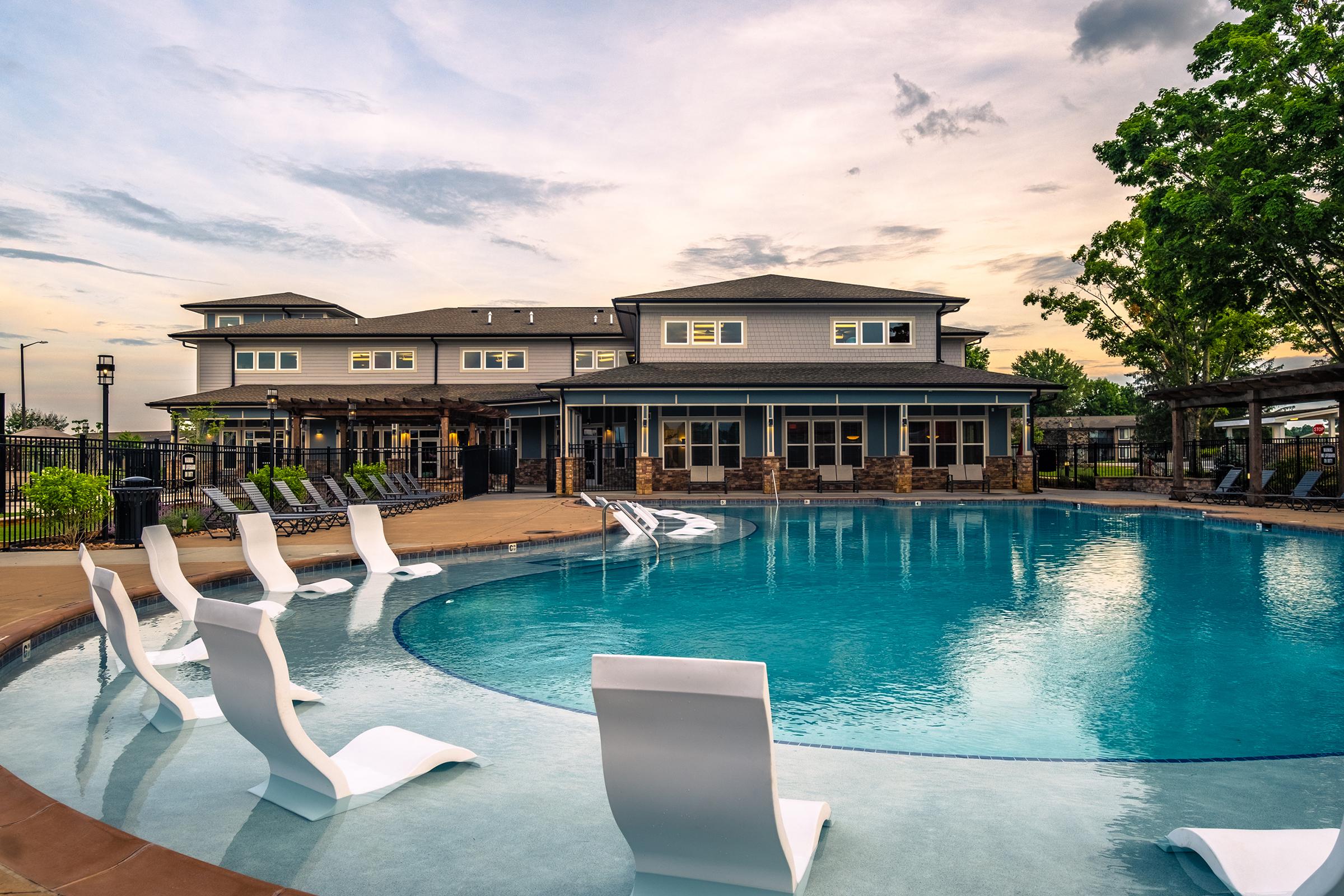 a group of lawn chairs sitting next to a pool of water