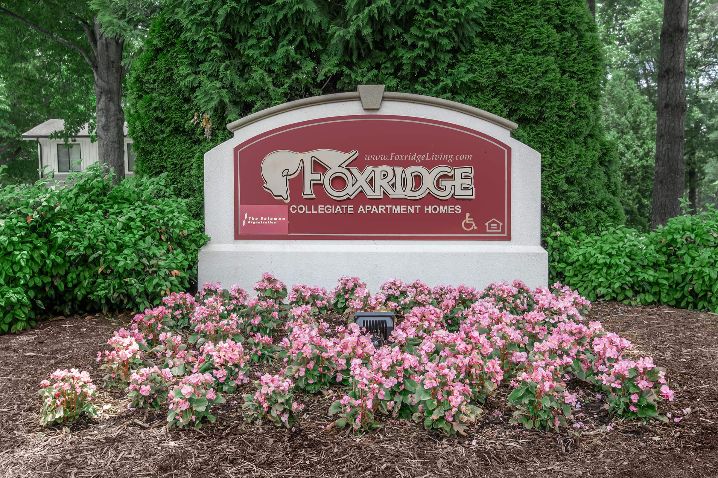 a sign in front of a flower garden