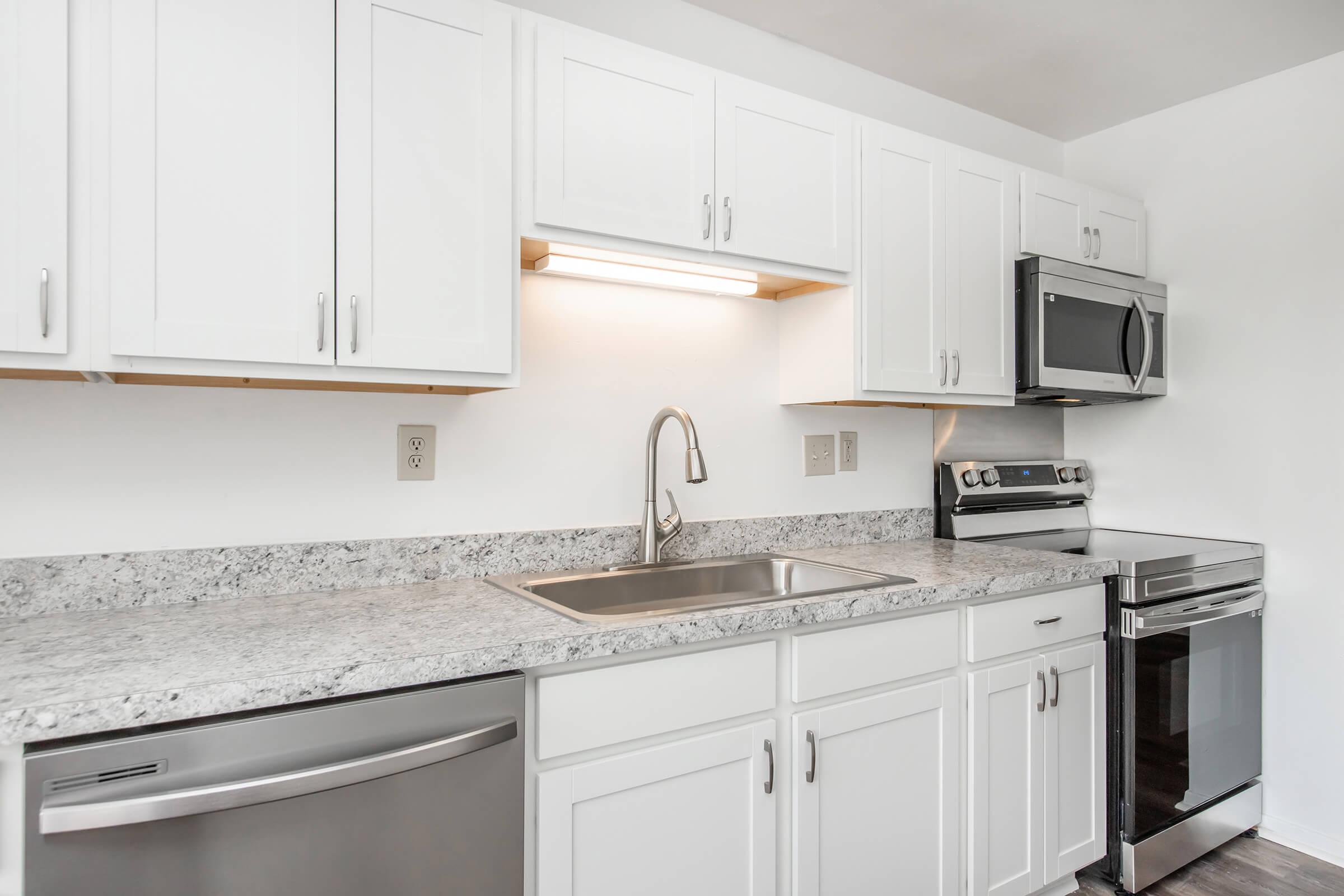 a kitchen with a stove a sink and a microwave