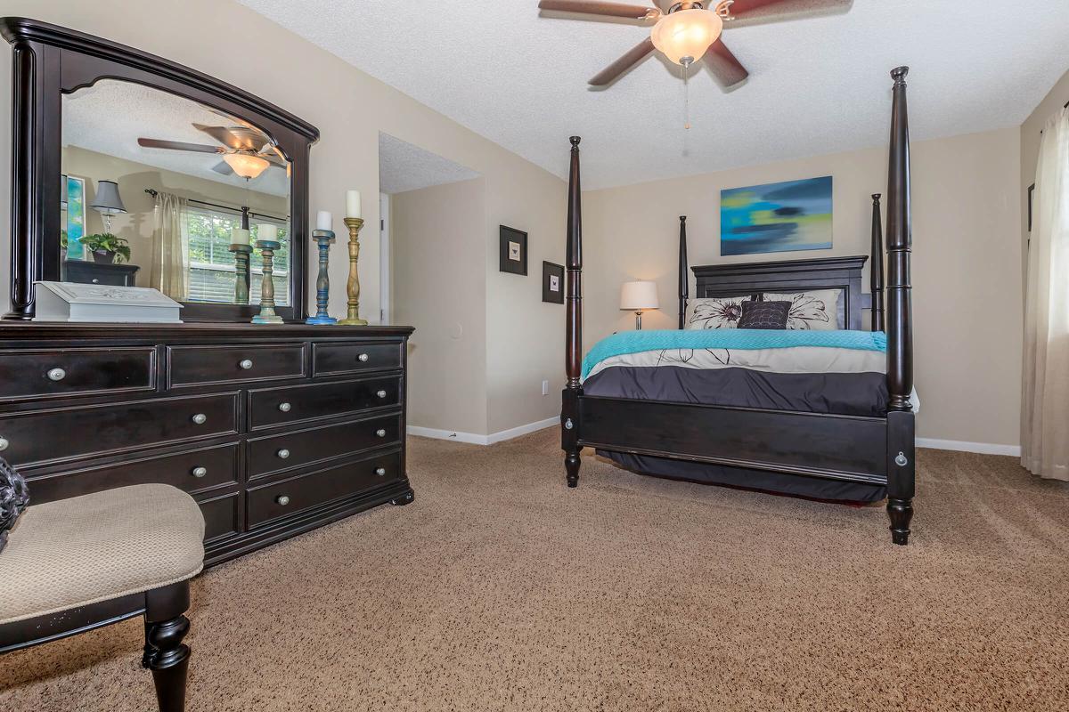 a bedroom with a bed and a chair in a room