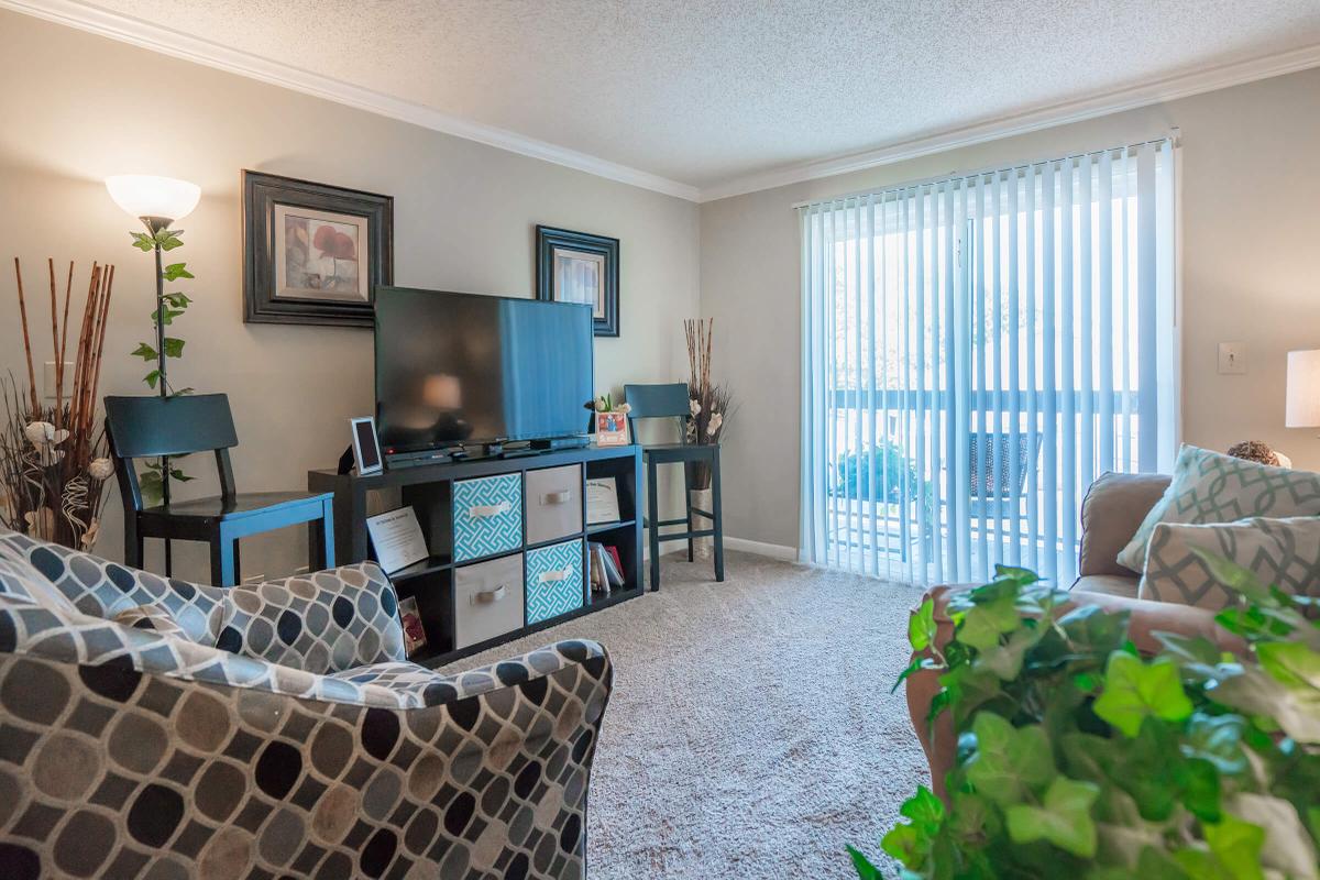 a living room filled with furniture and a large window