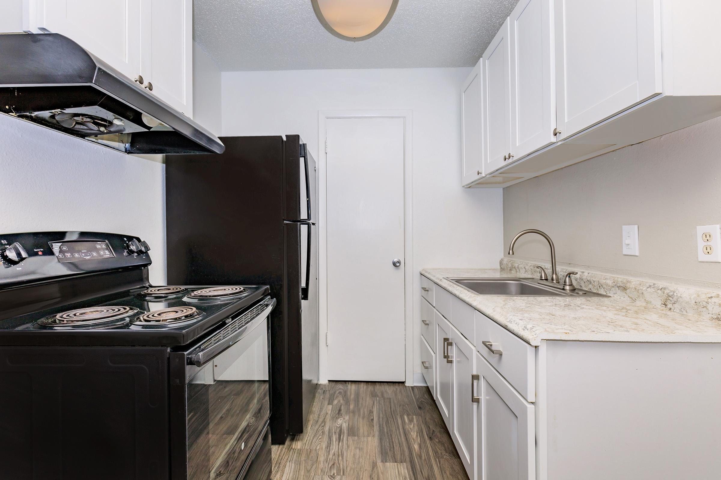 a stove top oven sitting inside of a kitchen