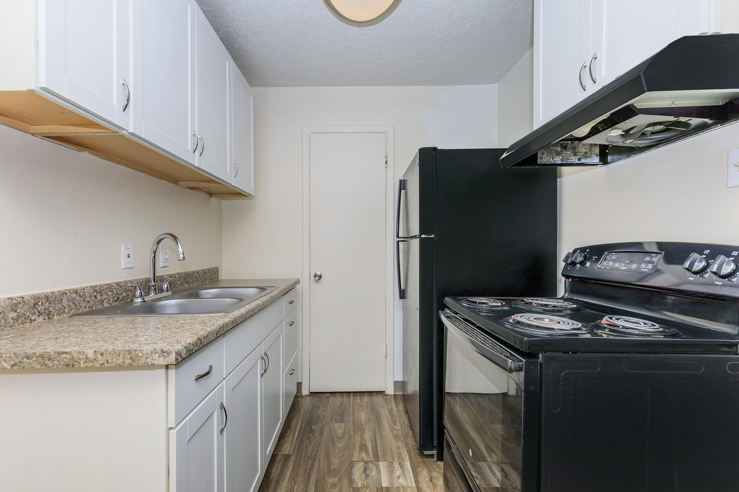 a kitchen with a stove sink and refrigerator