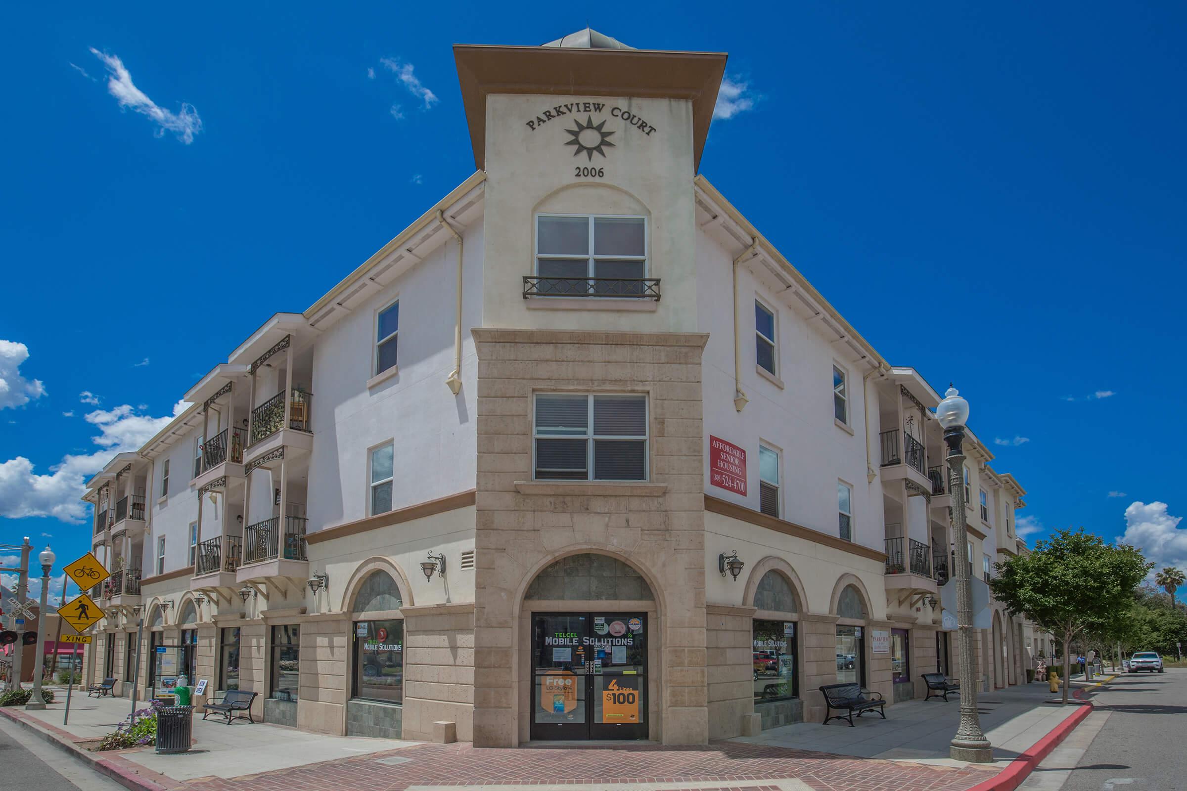 a large brick building with a clock on the side of a road