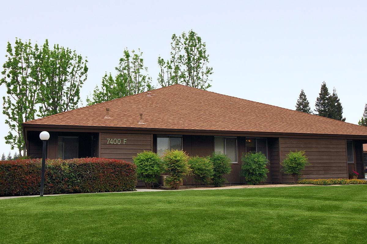 a large brick building with green grass in front of a house