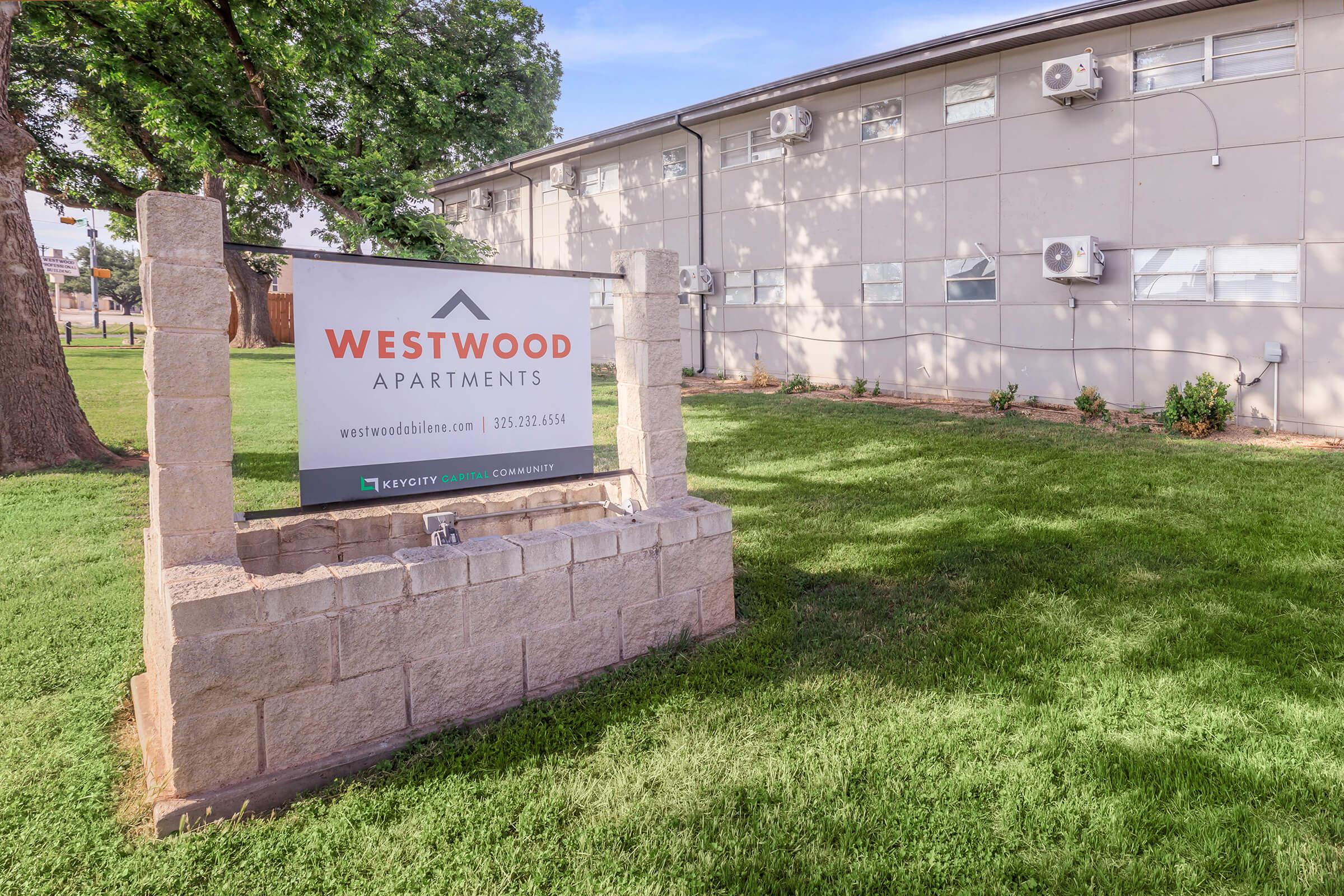 a yard that has a sign on the side of a building