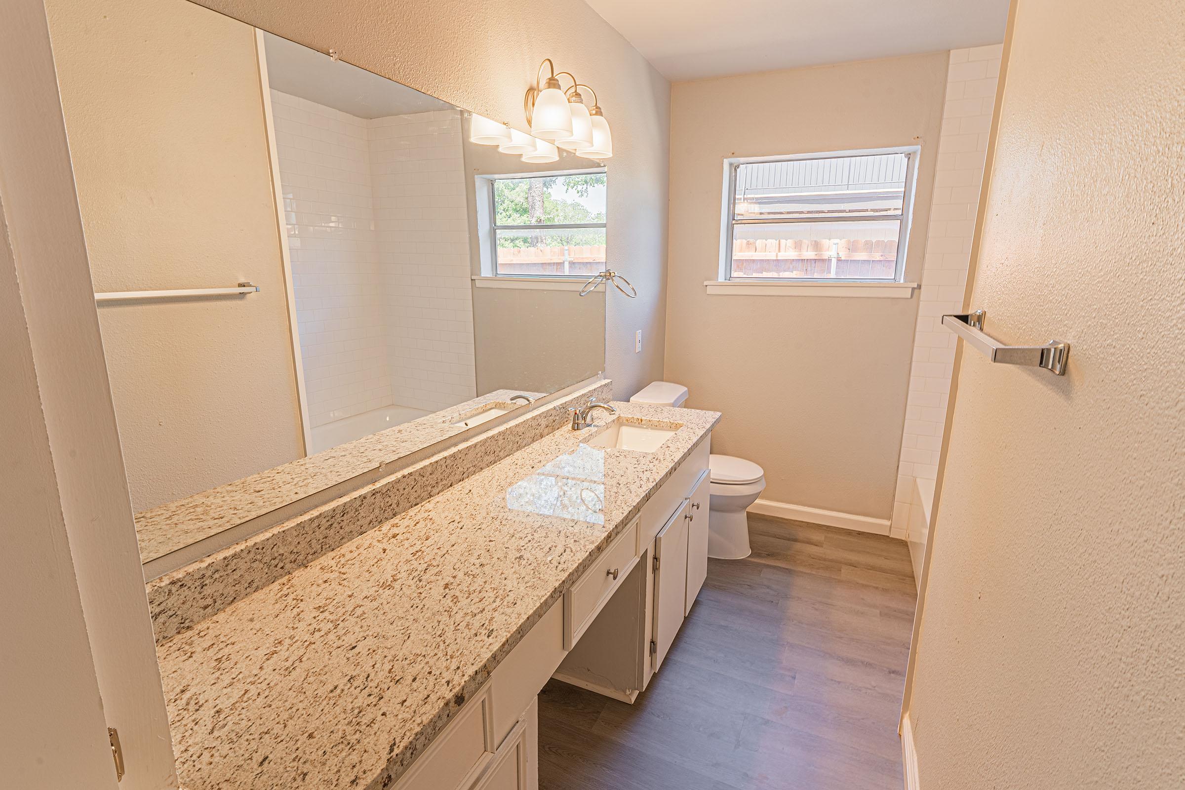 a bedroom area with a sink and a mirror