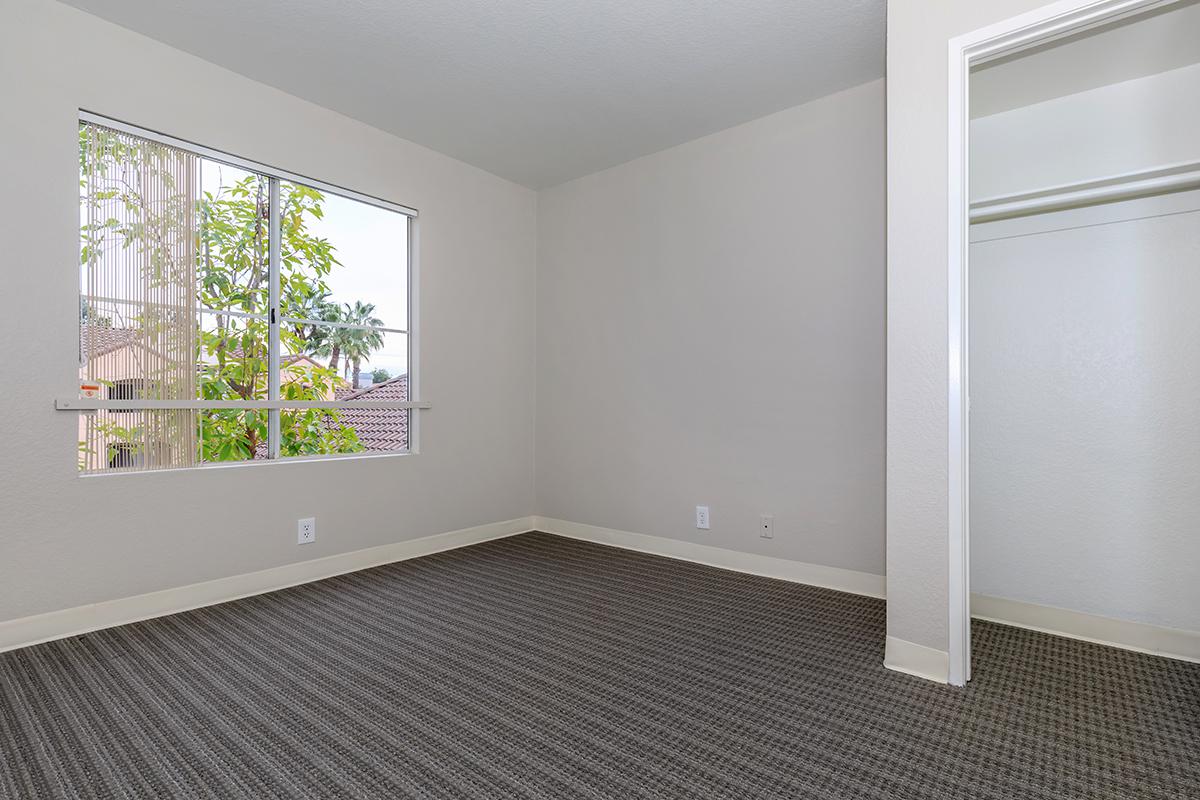 Carpeted bedroom with open window blinds