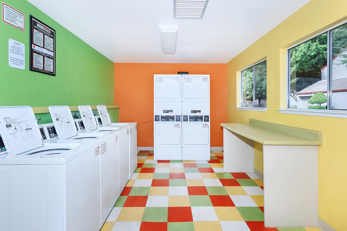 a kitchen with white cabinets and black furniture