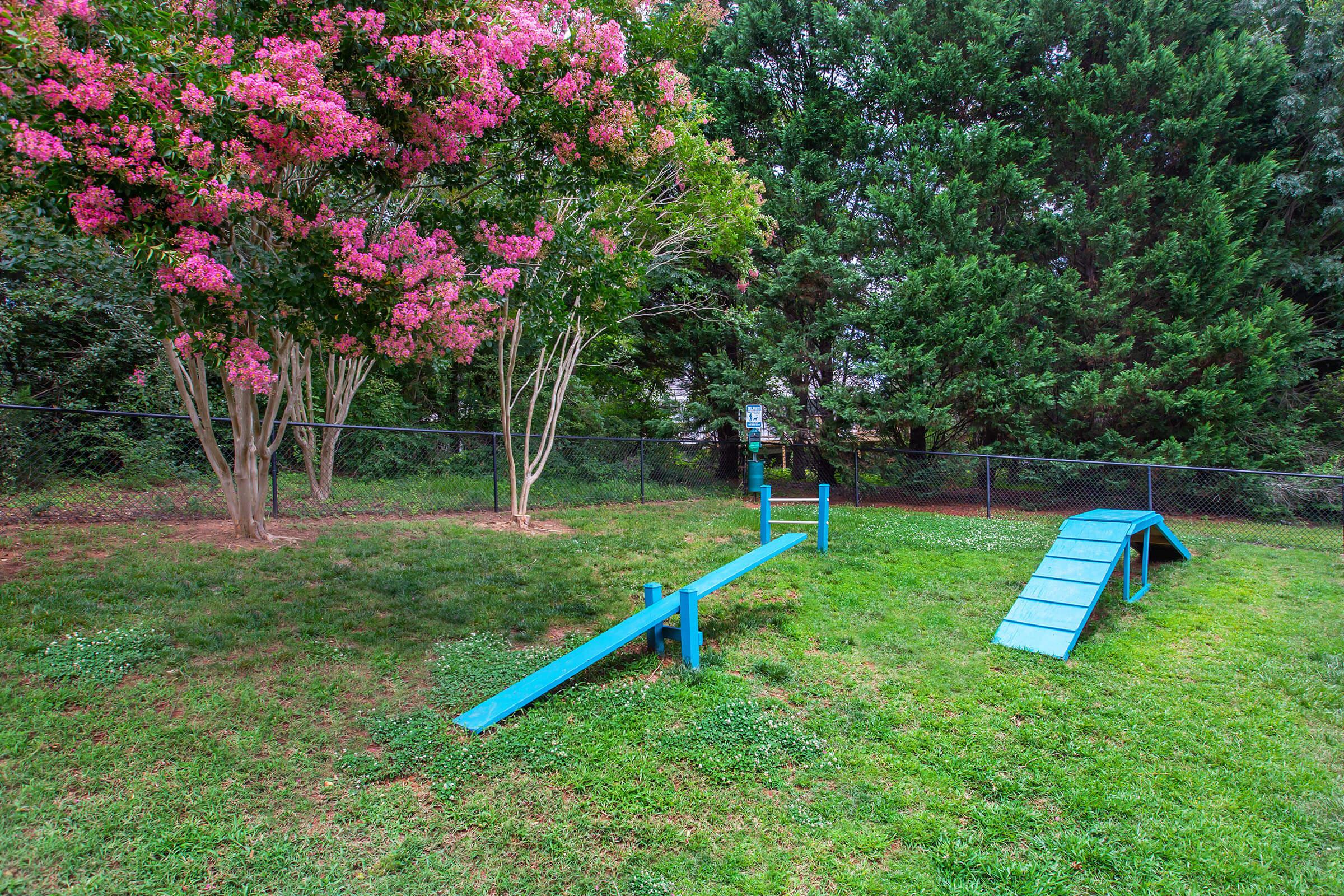 a couple of lawn chairs sitting on top of a grass covered field