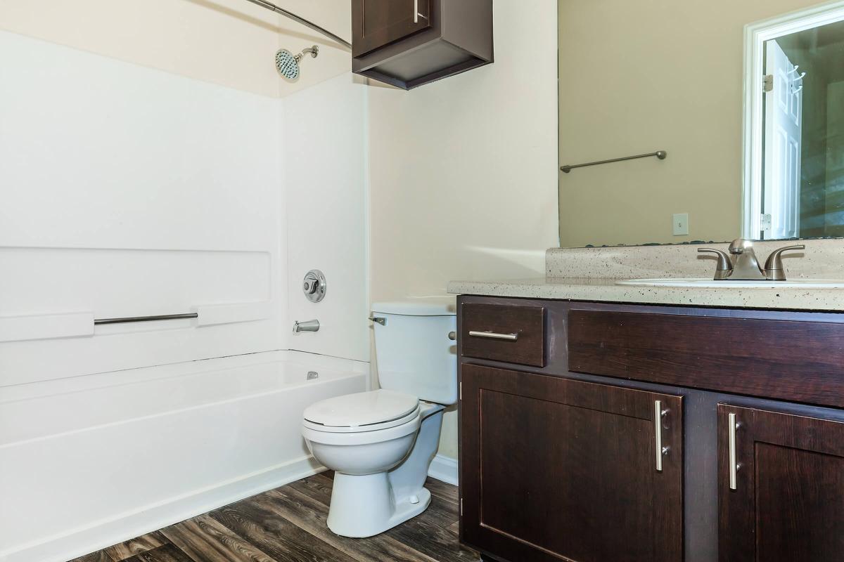 a white sink sitting under a mirror