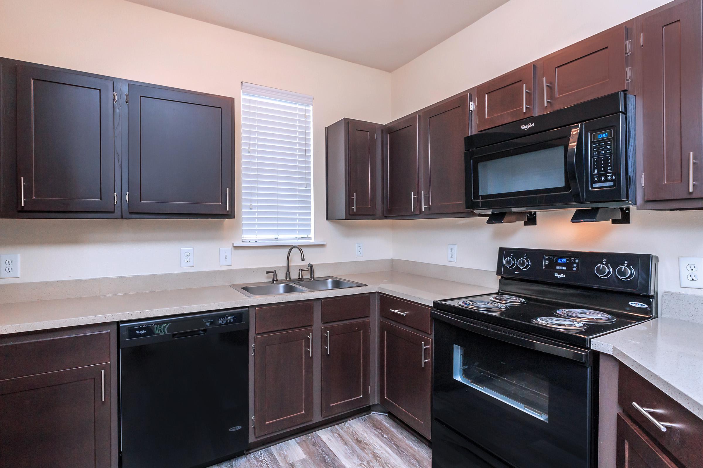 a modern kitchen with stainless steel appliances and wooden cabinets