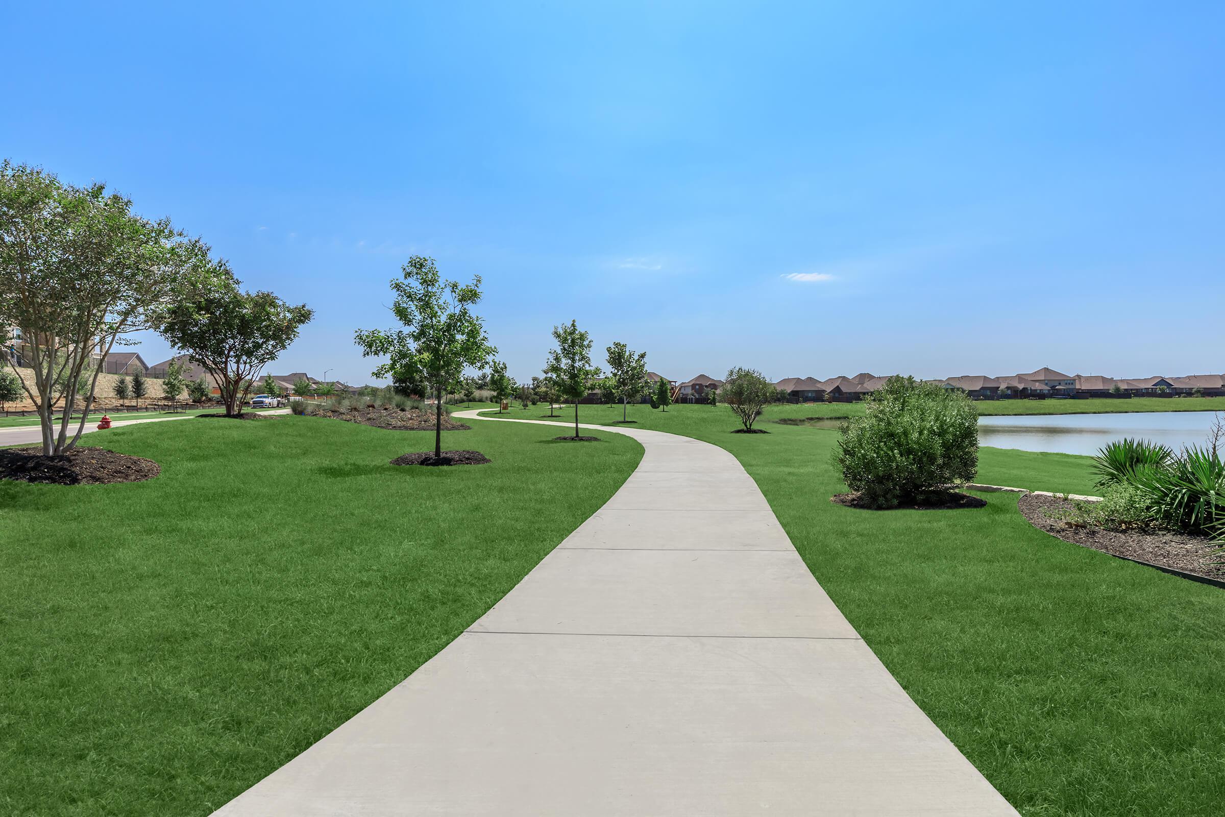 a large green field with trees in the background