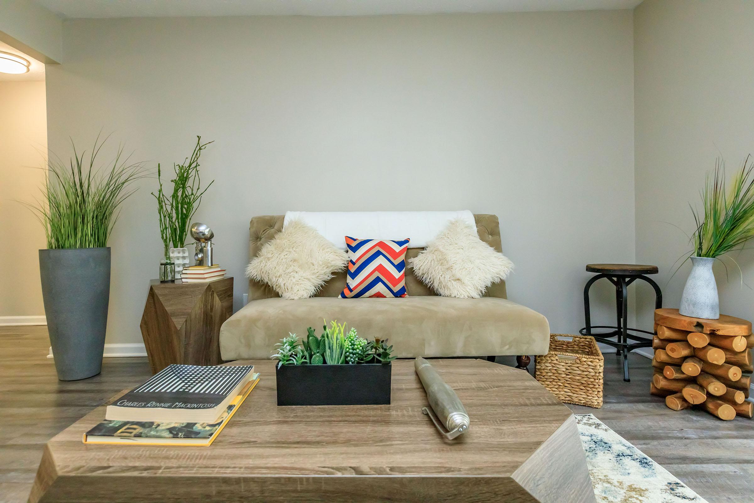 a living room filled with furniture and vase of flowers on a table