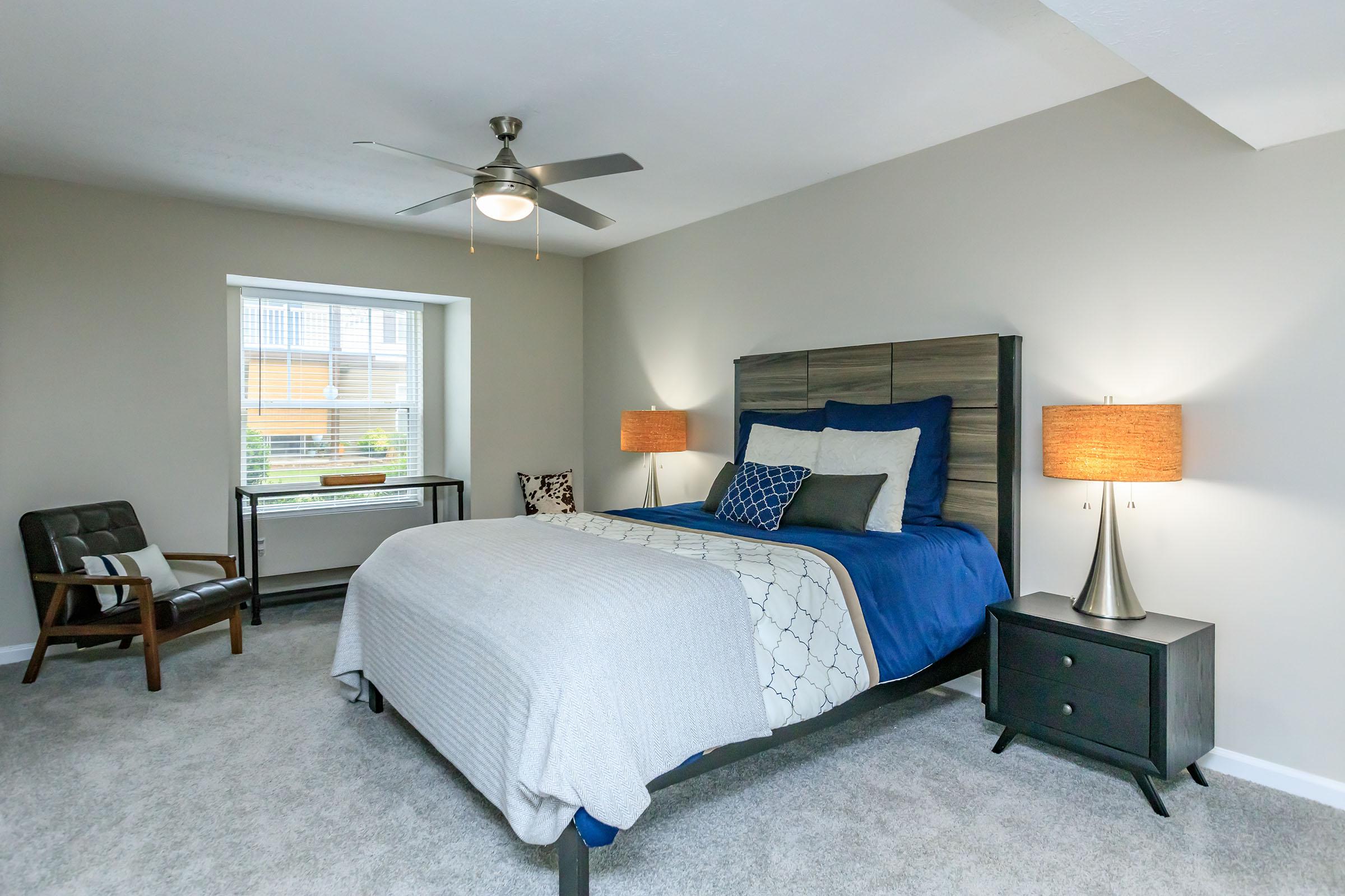 a bedroom with a bed and desk in a room