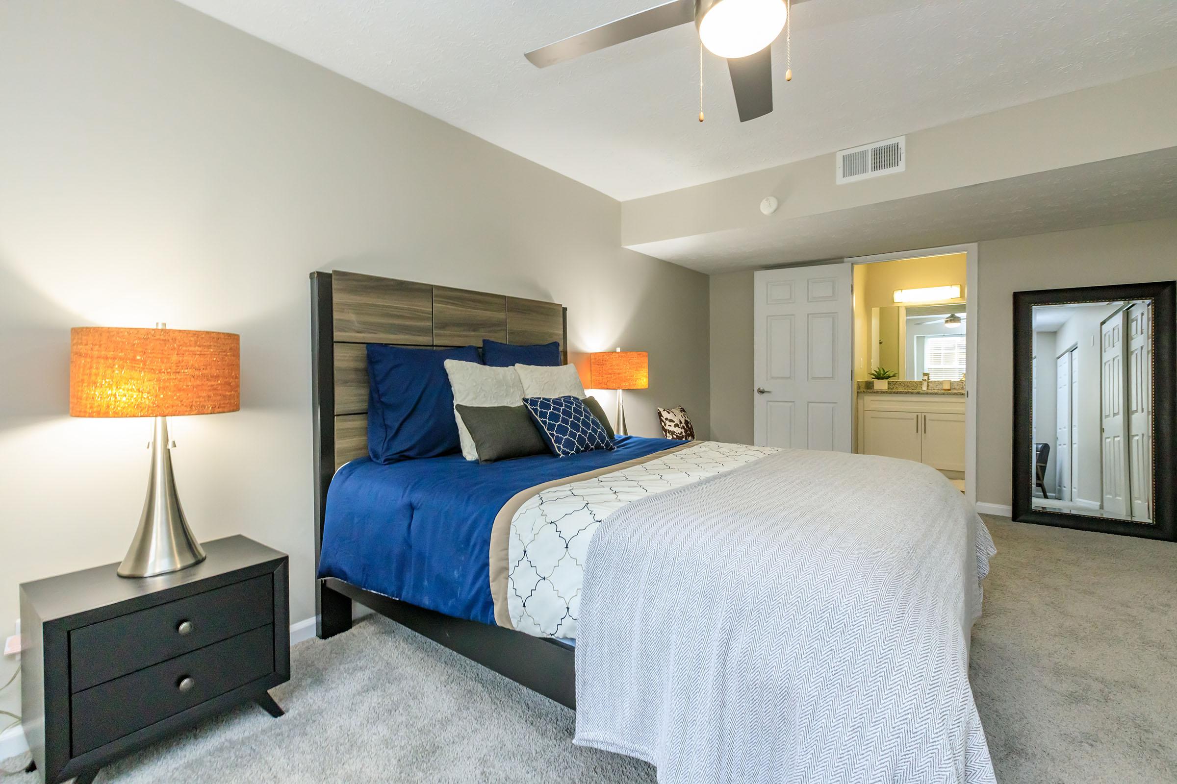 a bedroom with a bed and desk in a room