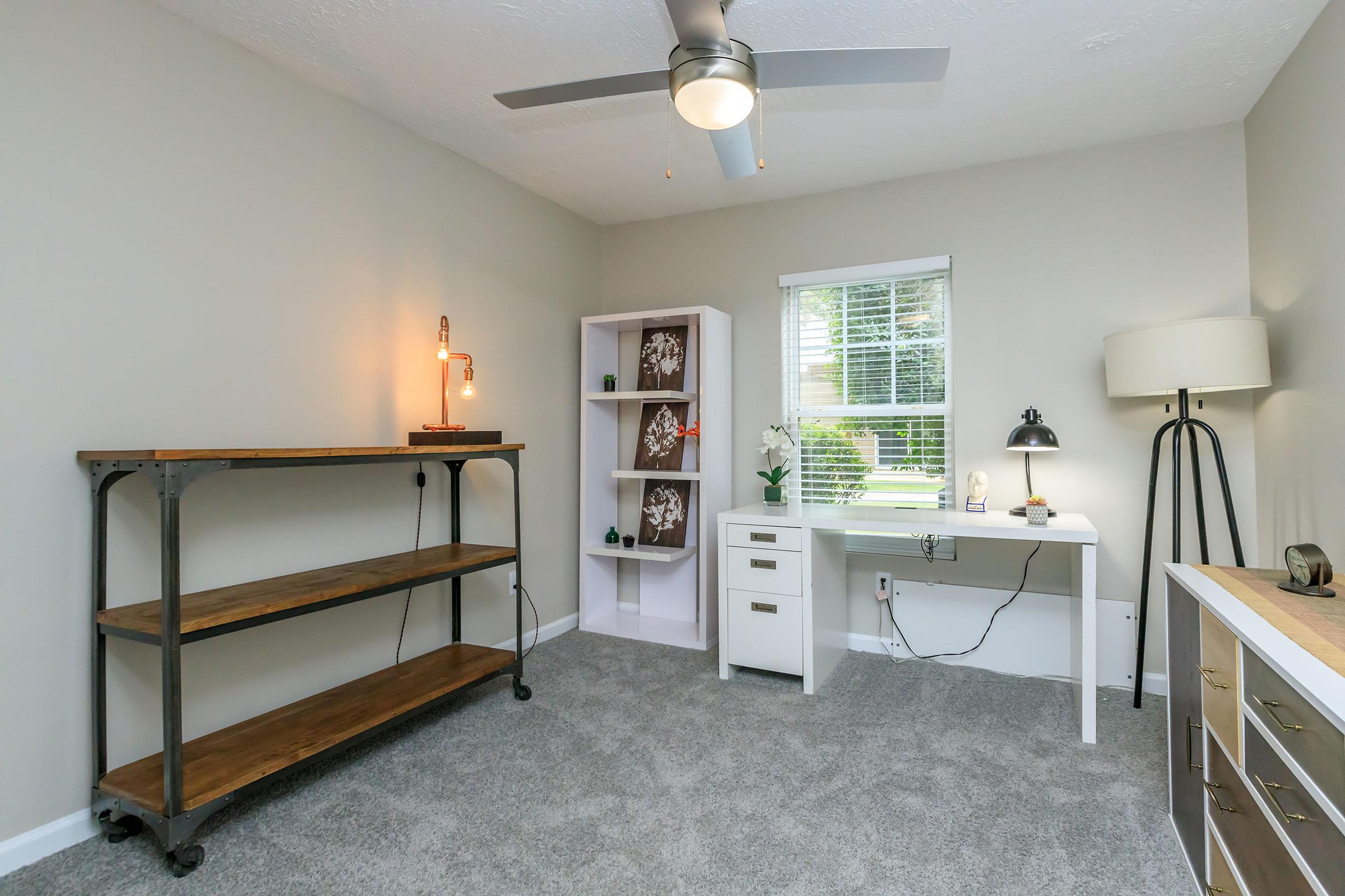 a bedroom with a bed and desk in a small room