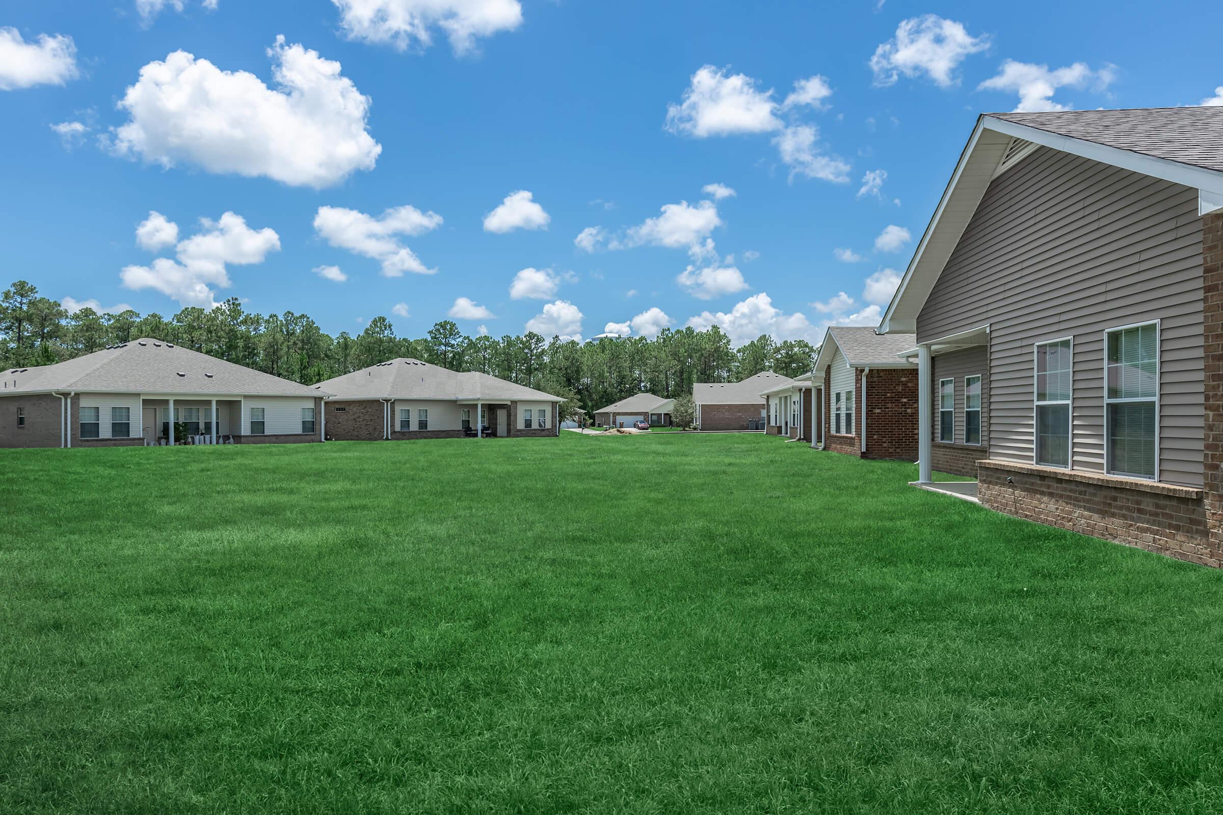 a large brick building with a grassy field