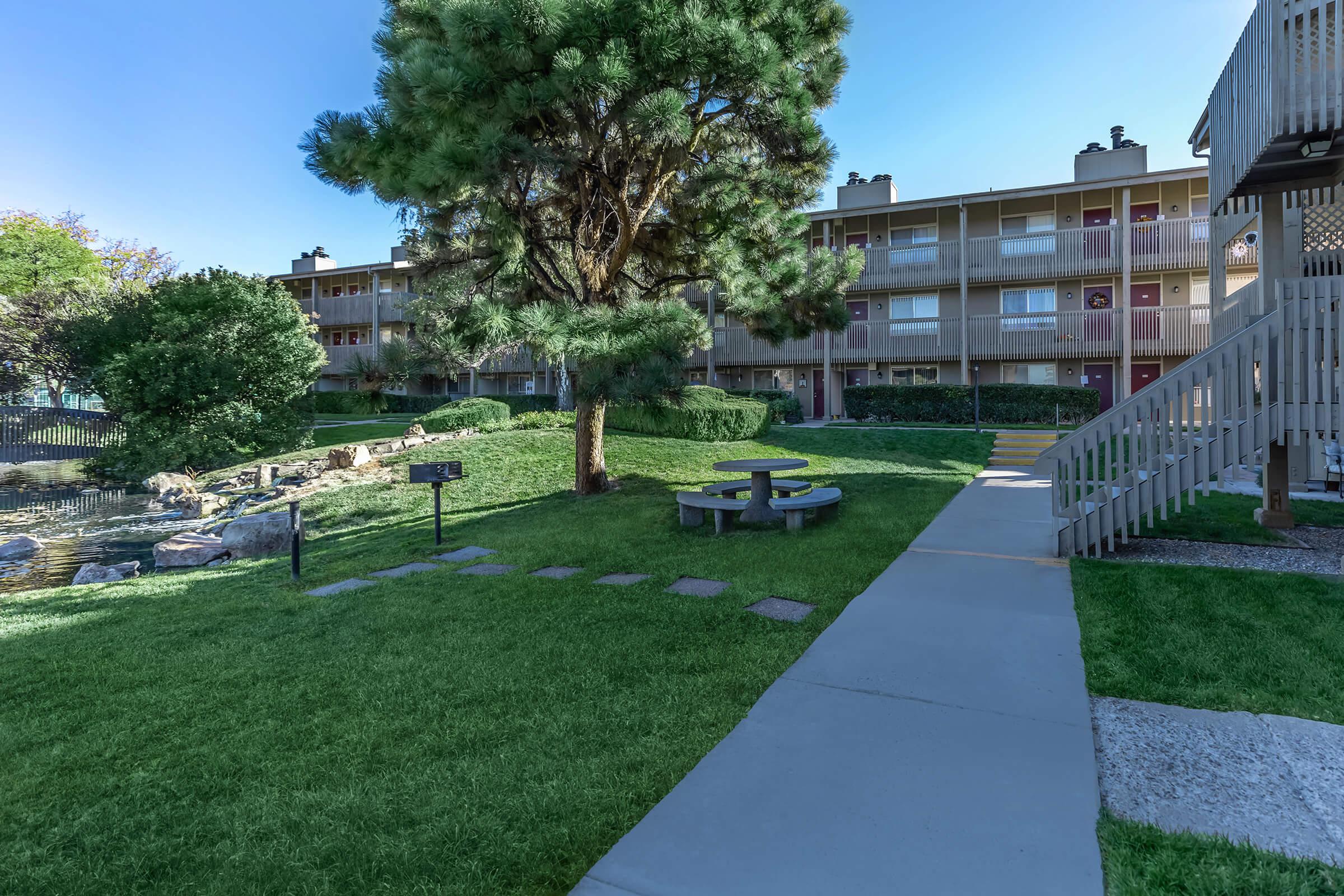 a picnic table and barbecues with green grass