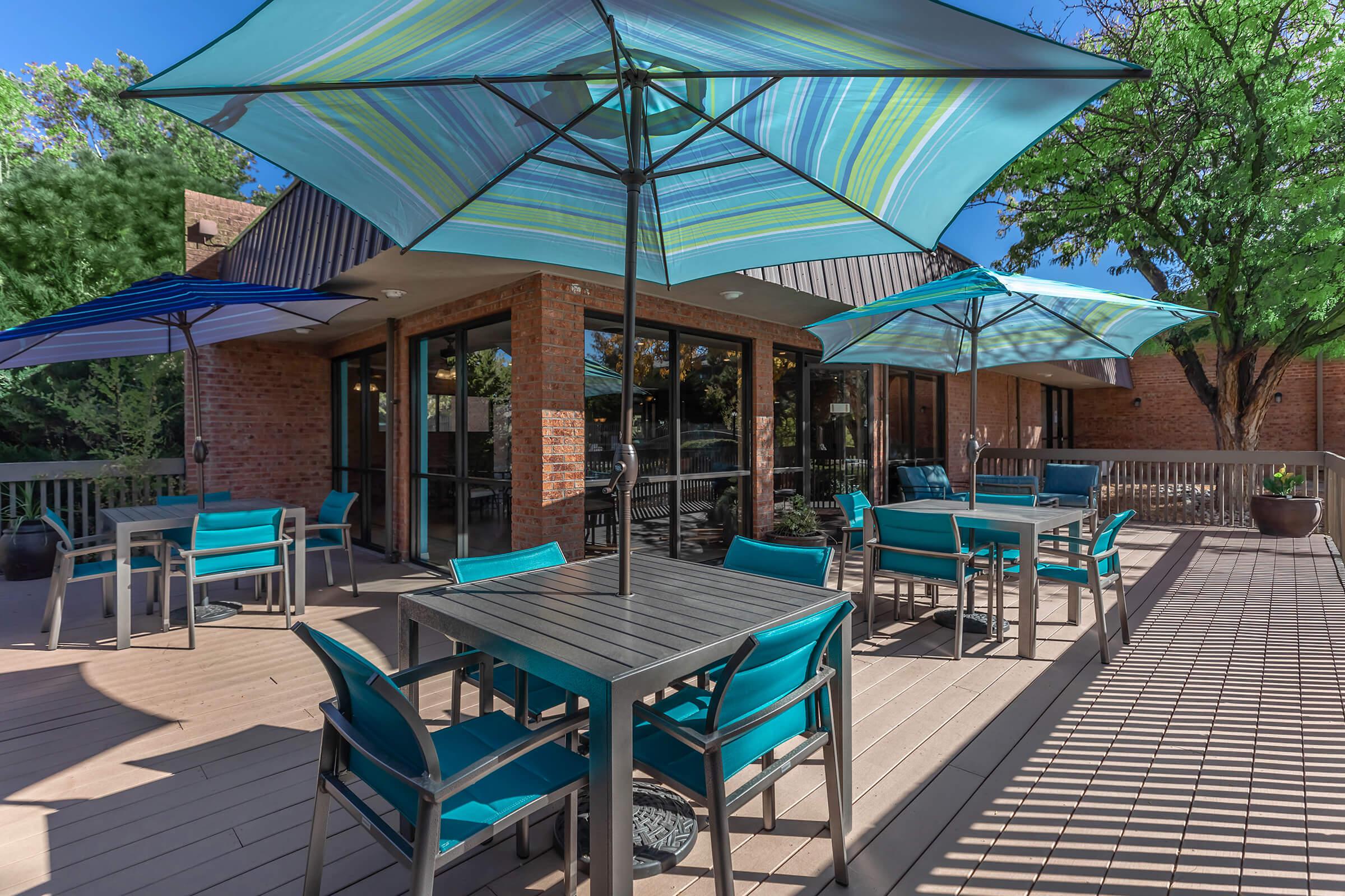 tables and chairs with striped umbrellas