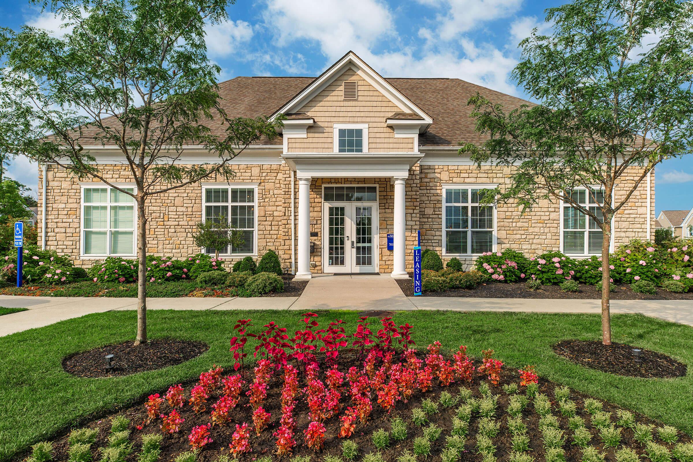 a close up of a flower garden in front of a house