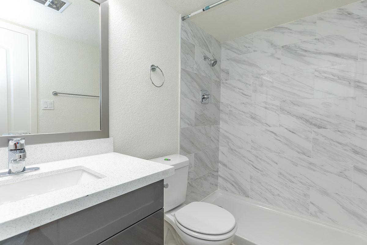 a white sink sitting under a mirror