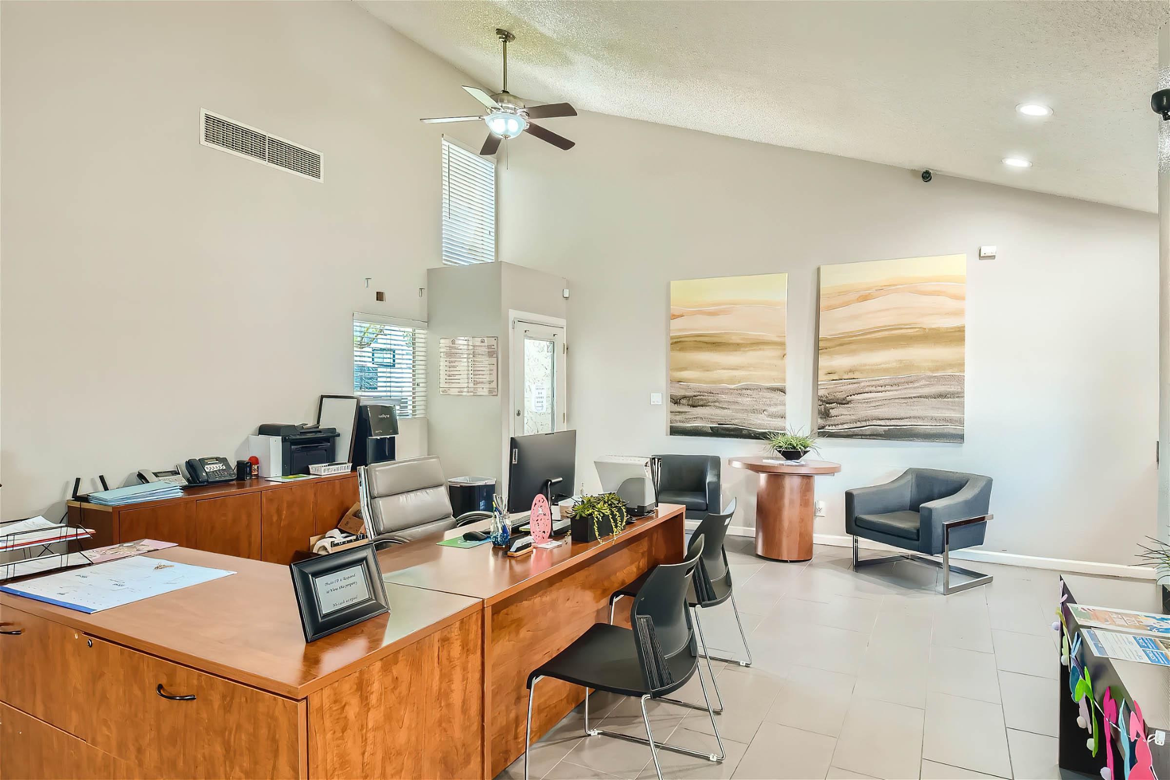 Inside the Rise at Dobson Ranch apartment leasing office with a long desk and several chairs