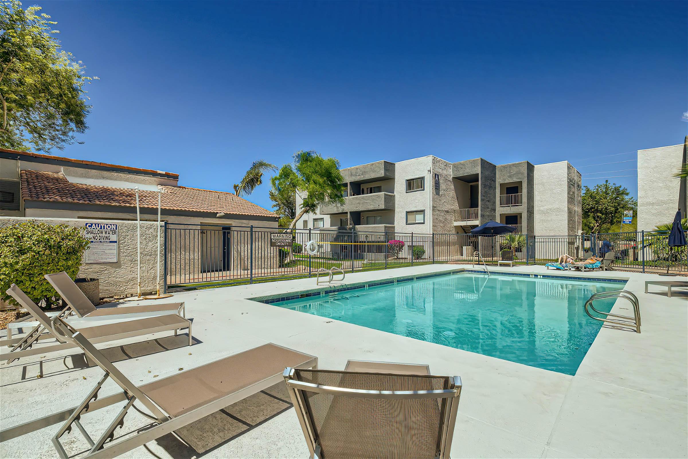 Lounge chairs in front of an outdoor pool at Rise at Dobson Ranch Mesa, AZ apartments