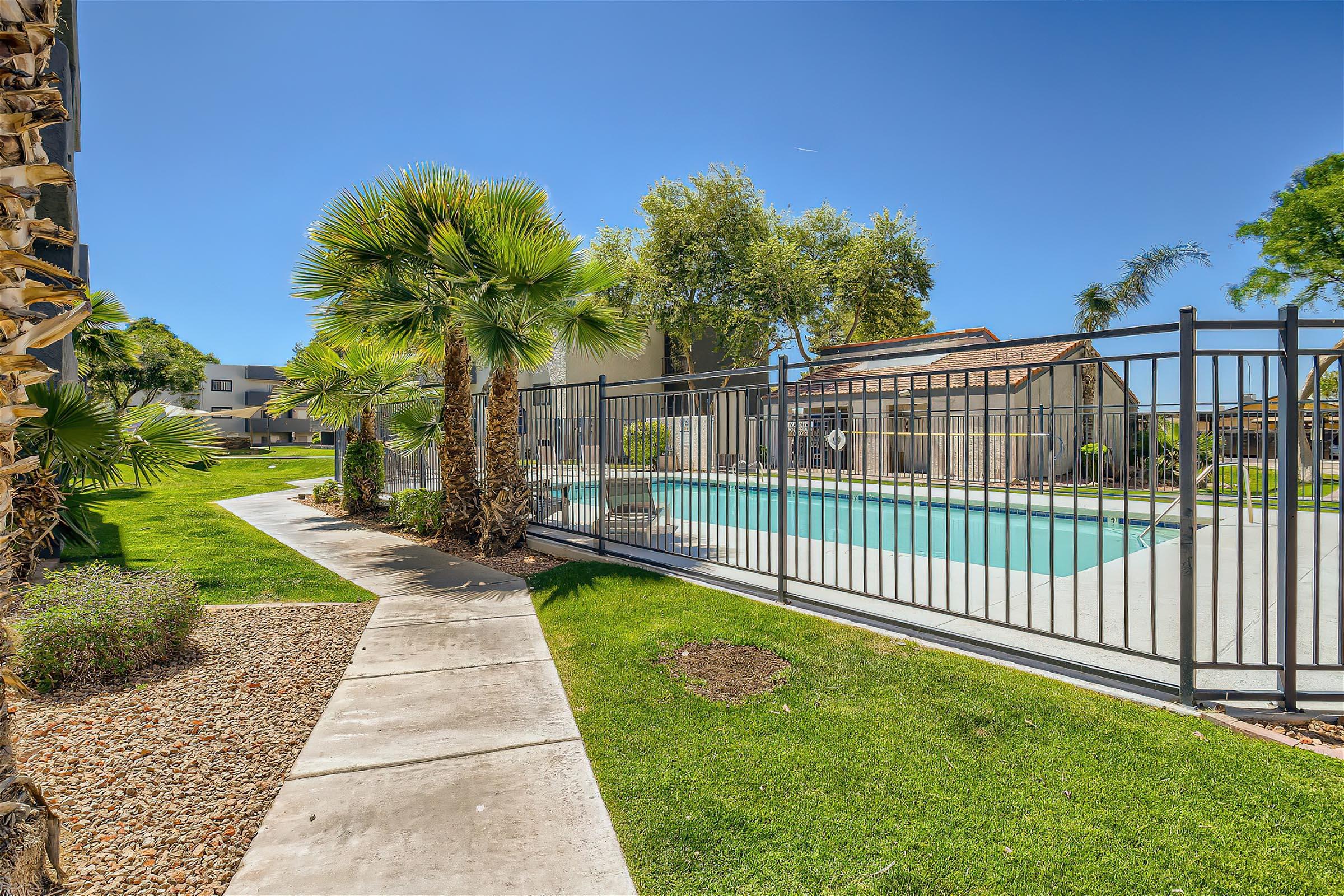 View of the Rise at Dobson Ranch outdoor swimming pool from behind an iron fence