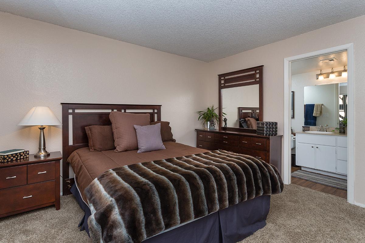a bedroom with a bed and desk in a room