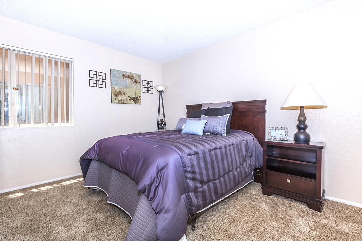 a bedroom with a bed and desk in a room