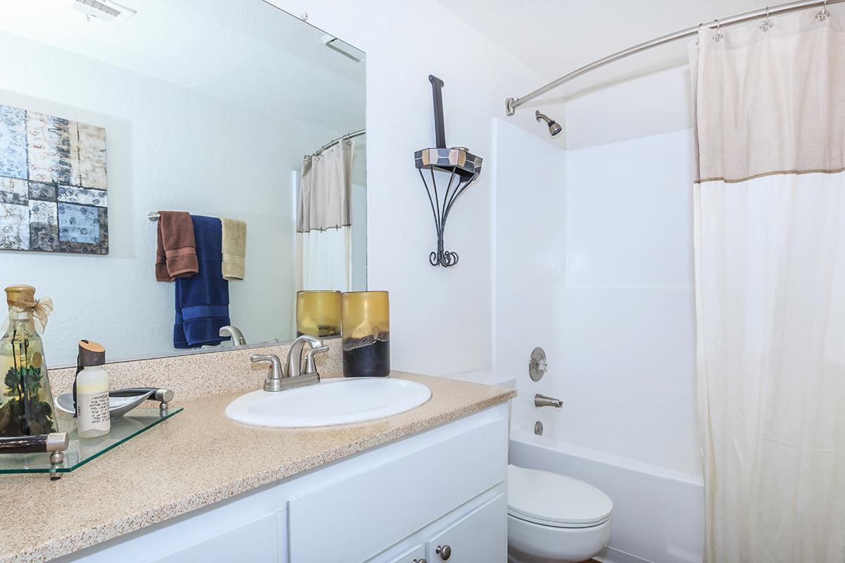 a white sink sitting next to a shower