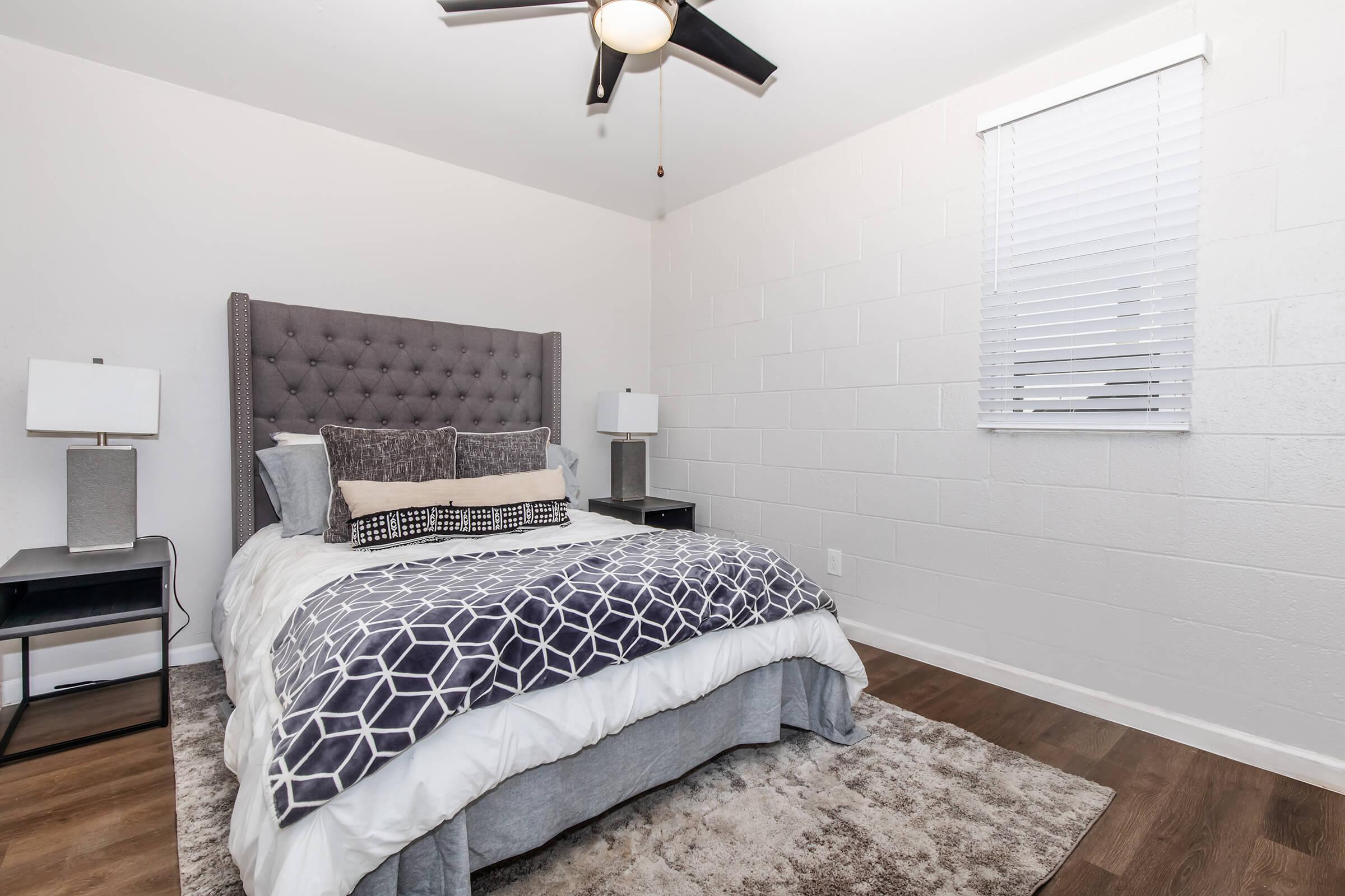 a bedroom with a bed and desk in a room