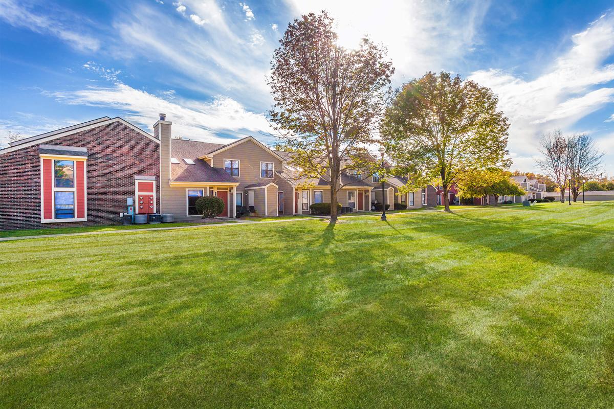 a large green field in front of a house