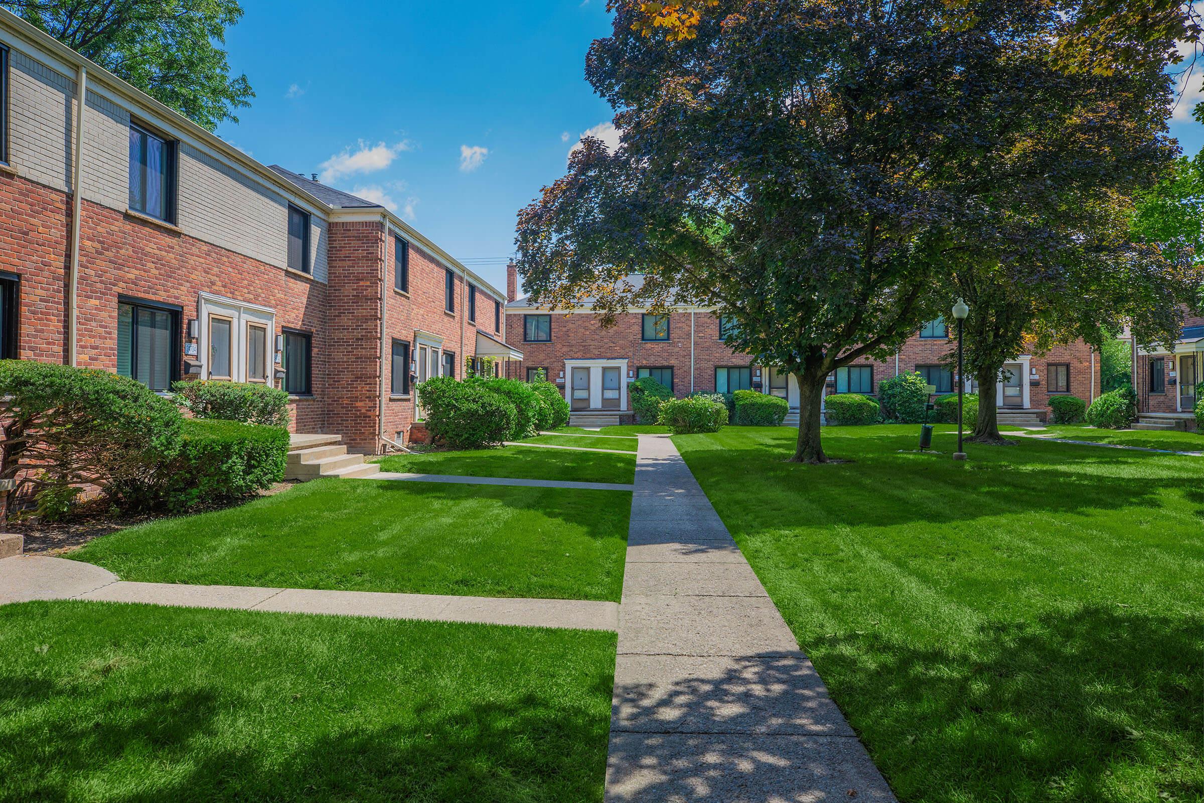 a large lawn in front of a brick building