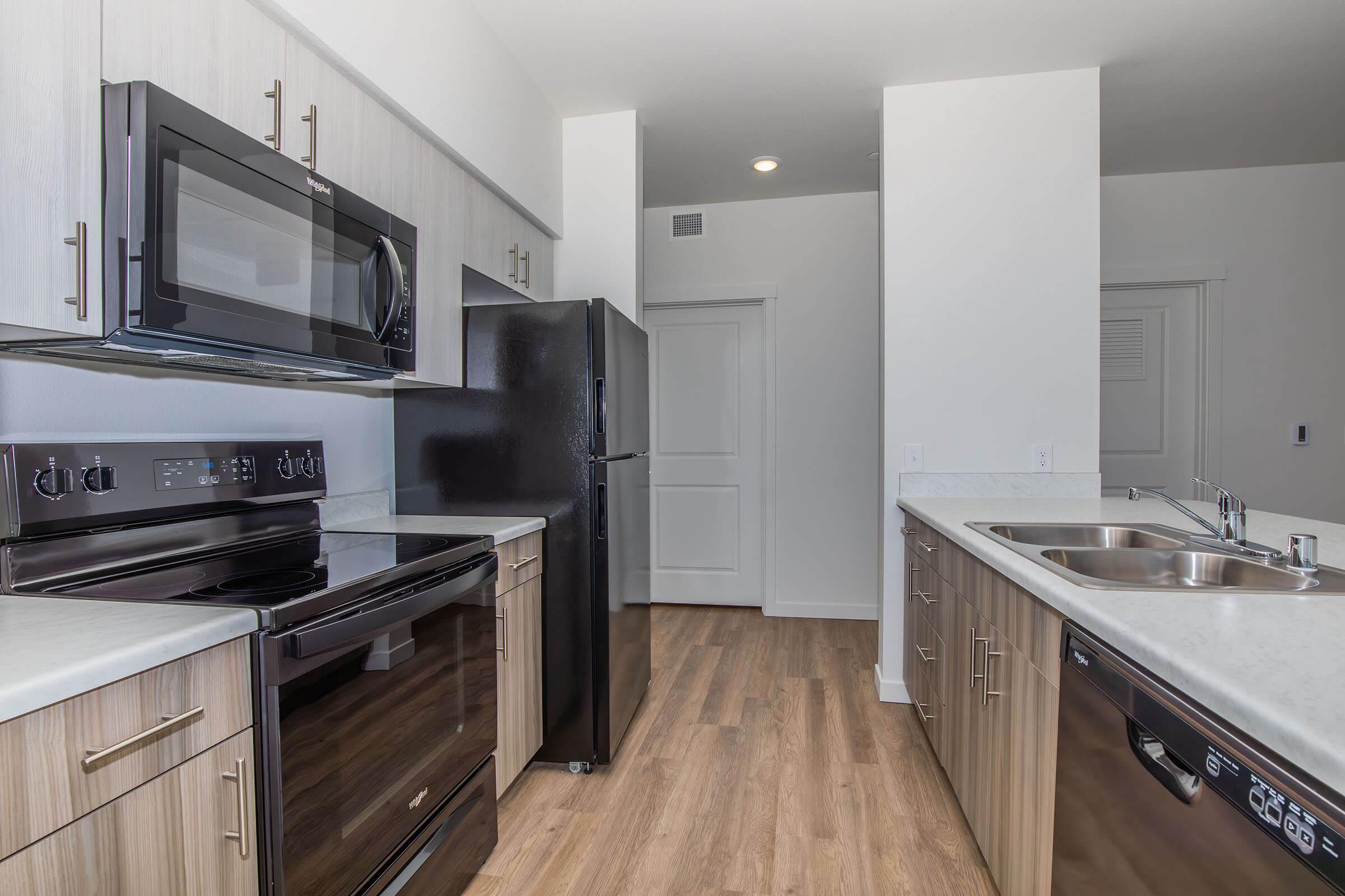 a modern kitchen with stainless steel appliances and wooden cabinets