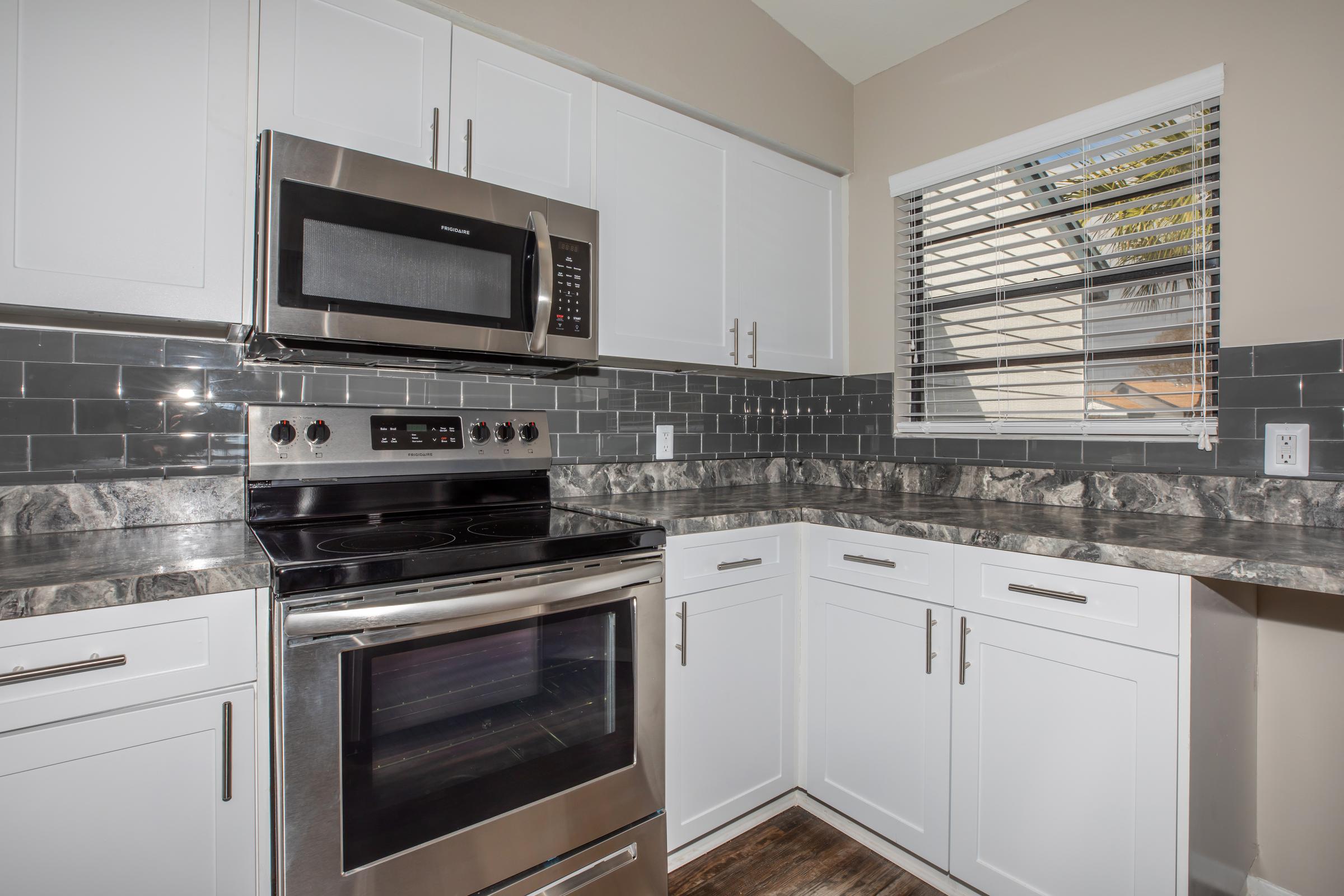 a stove top oven sitting inside of a kitchen